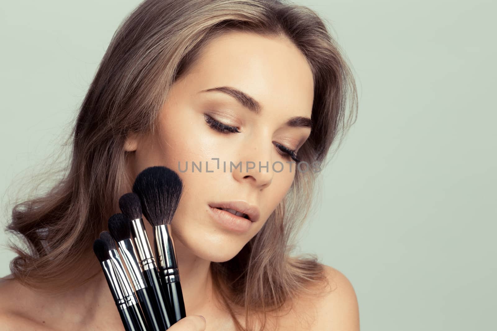 Portrait of beauty girl with makeup brushes set