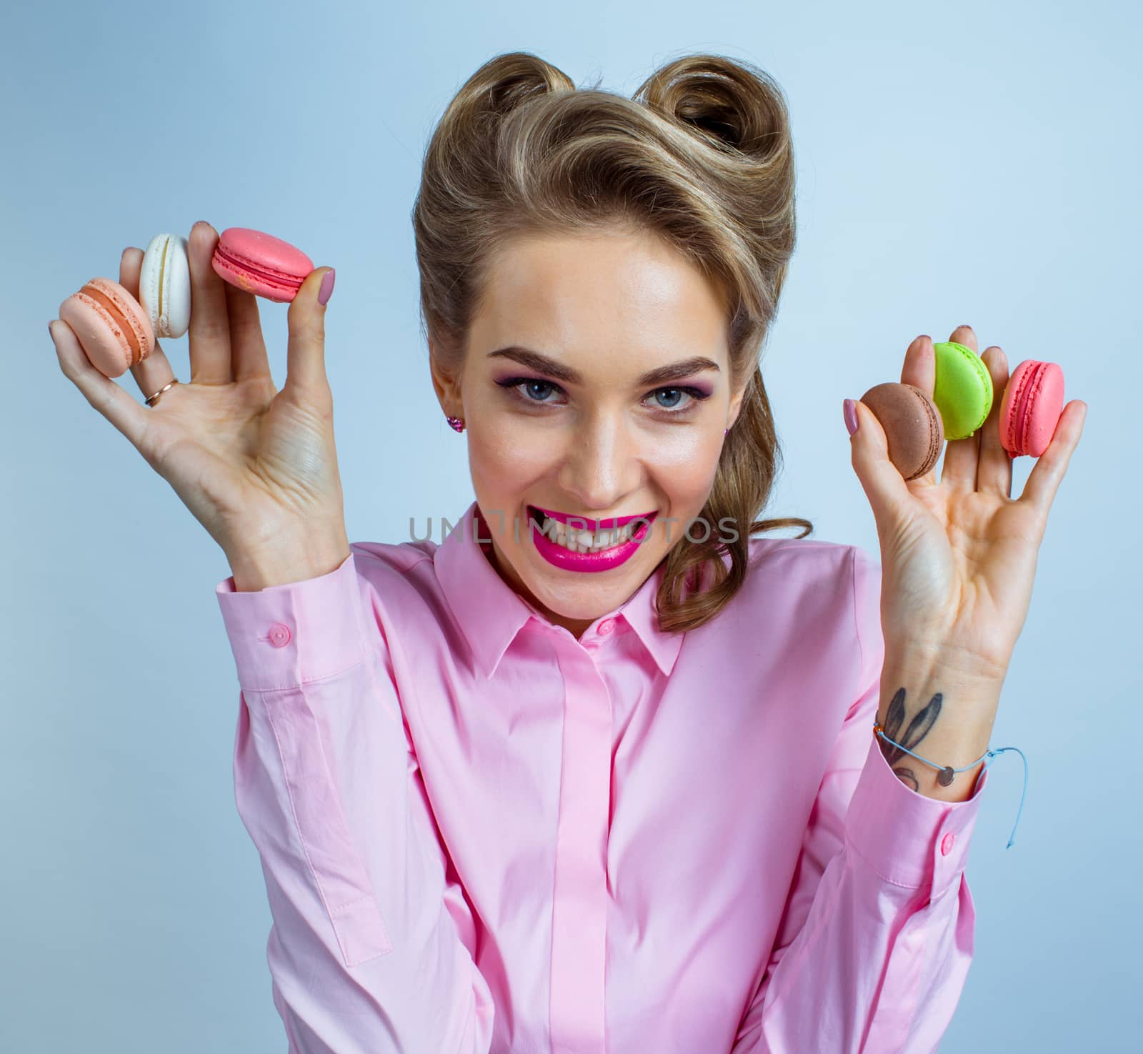 Happy beautiful woman with colourful macaroons in hands