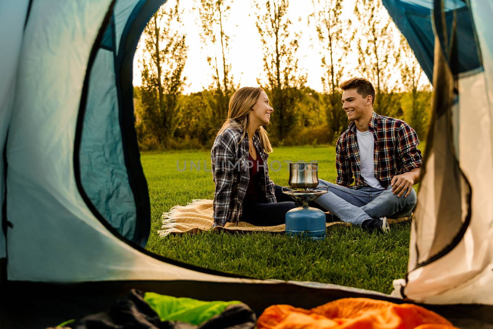 Shot of a happy couple camping on the nature and cooking