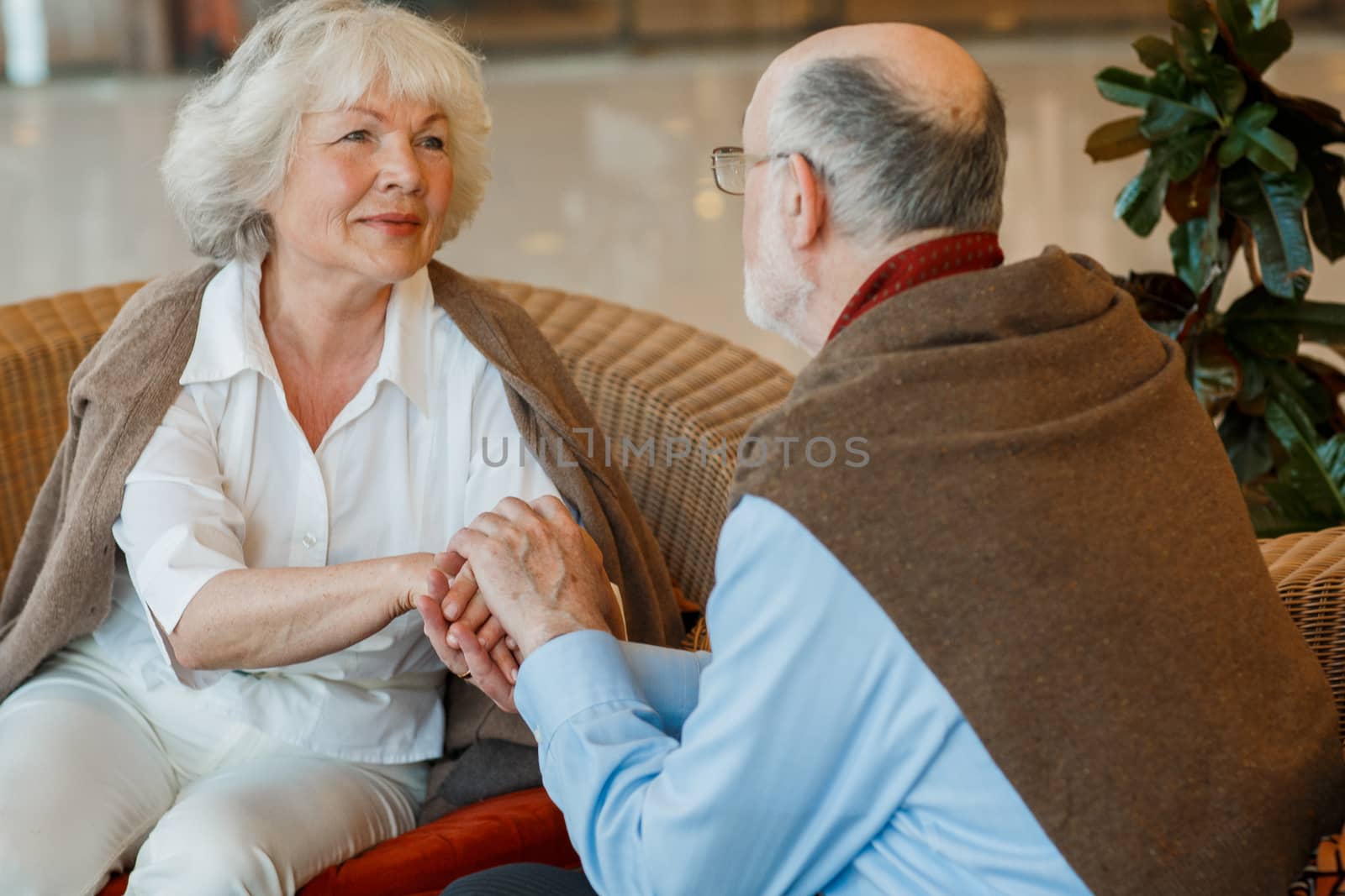 Romantic senior couple holding hands in cafe