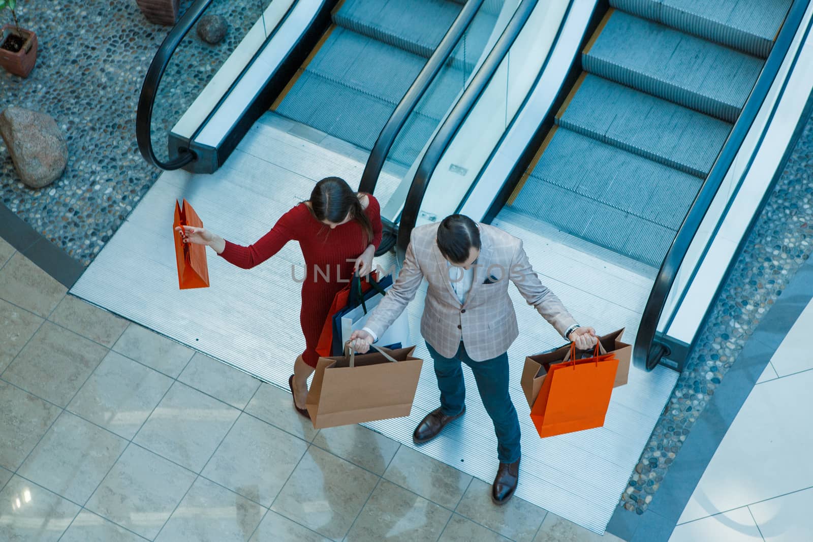 Happy beautiful young couple with shopping bags in mall