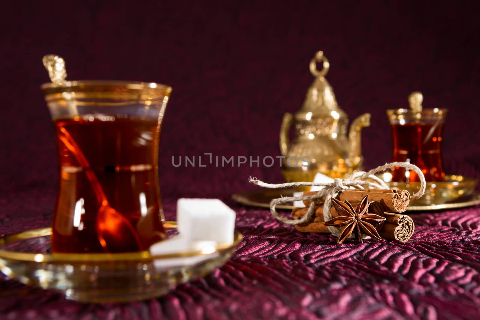 Closeup of Turkish tea in traditional glass with star anise and cinnamon sticks