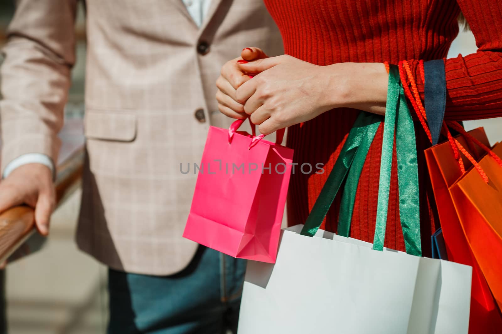 Couple with many colorful shopping bags in mall