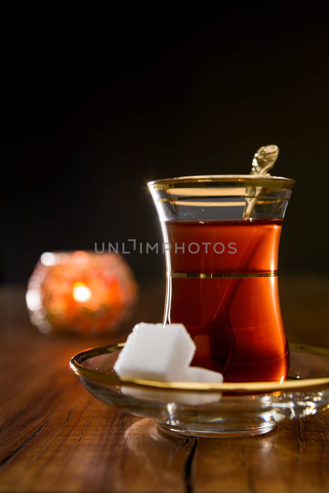 Turkish tea in traditional glass over a wooden background in backlight