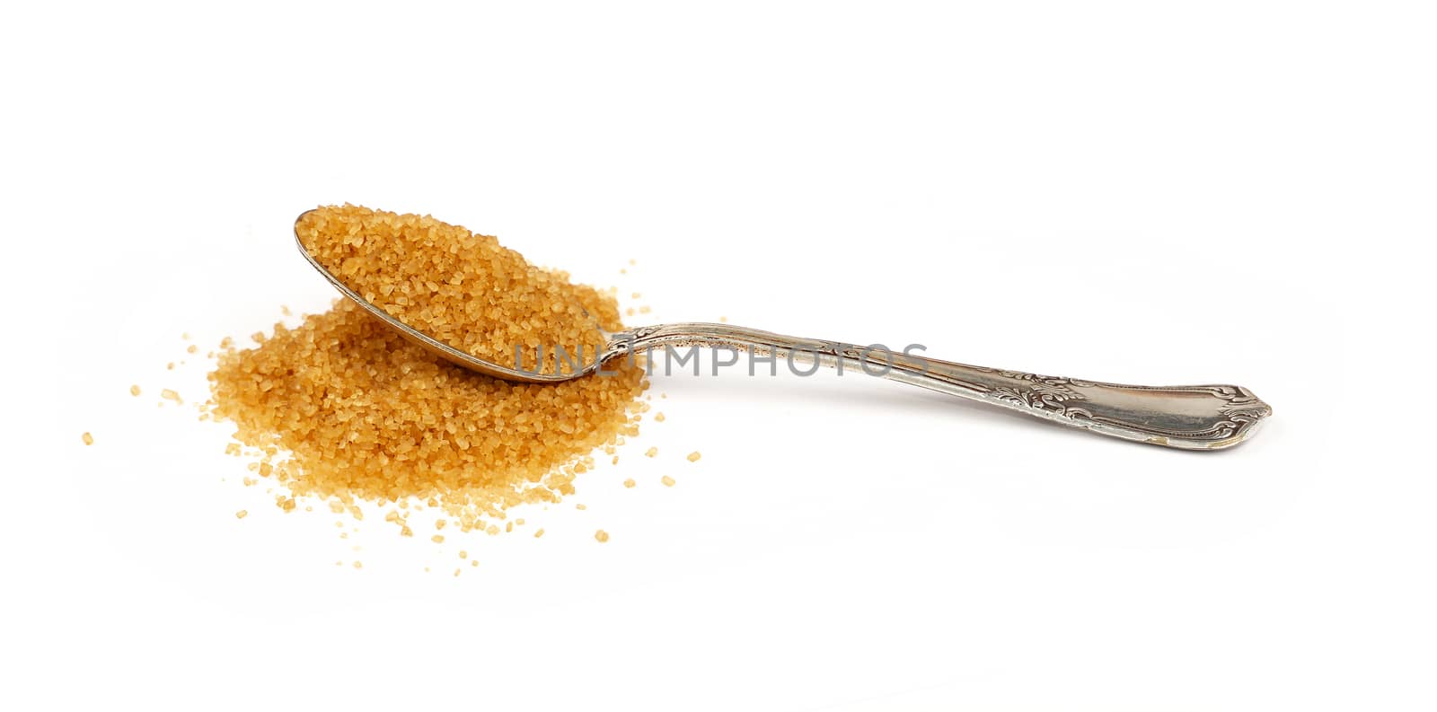 Close up one vintage silver metal spoon full of raw brown cane sugar with pinch spilled and spread around, isolated on white background, low angle side view