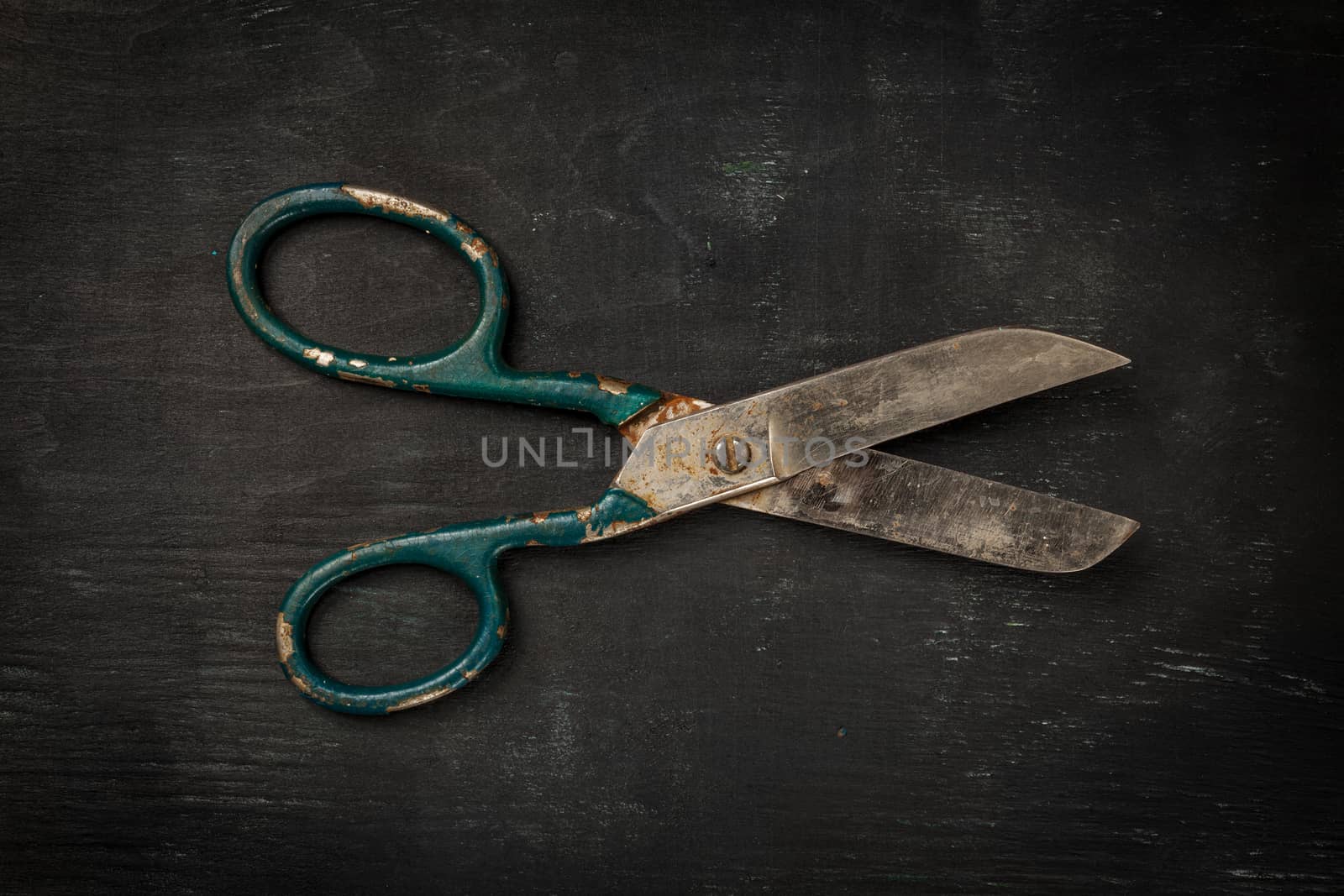 Retro sewing accessories - scissors on black wooden background