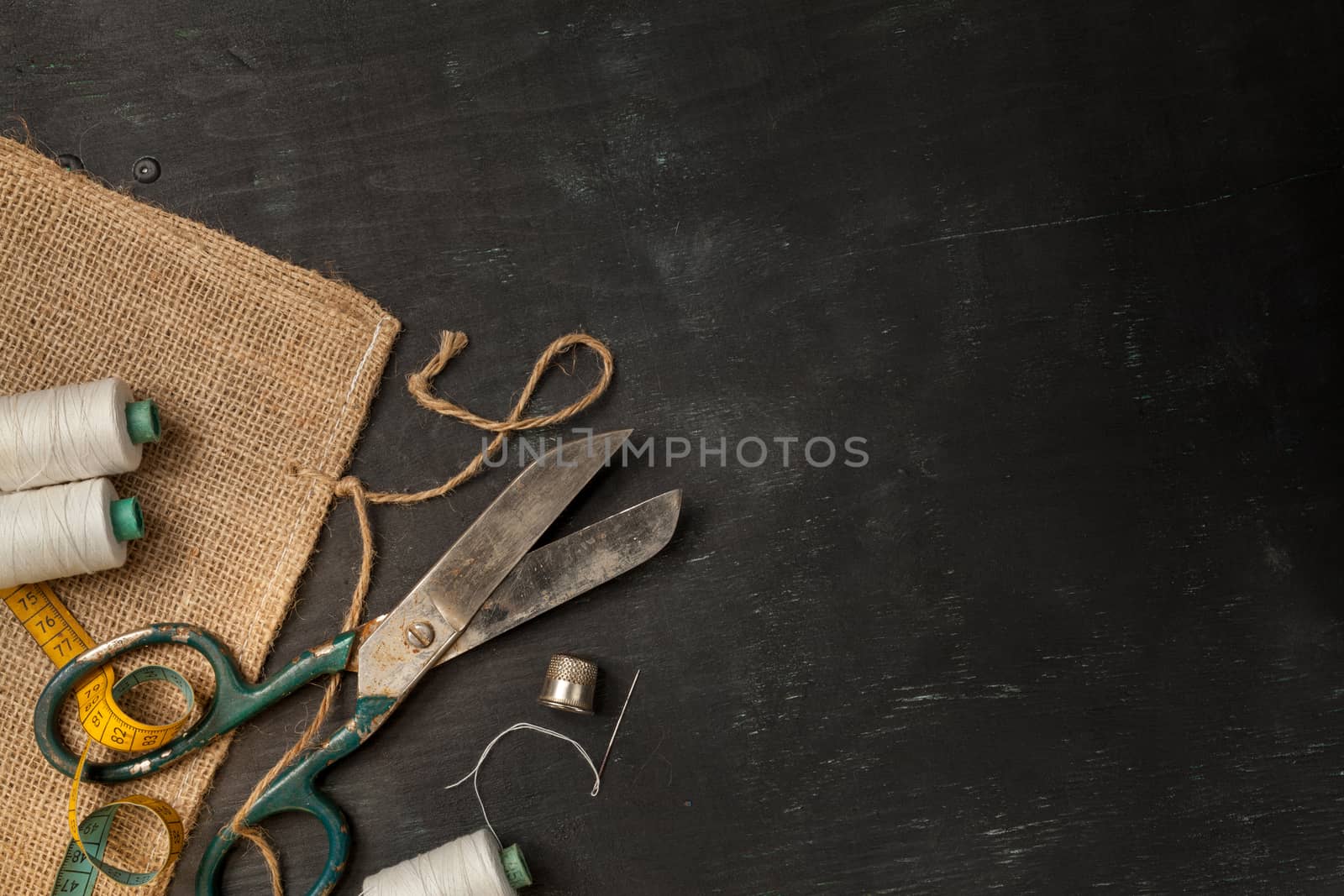 Retro sewing accessories on black wooden background by igor_stramyk