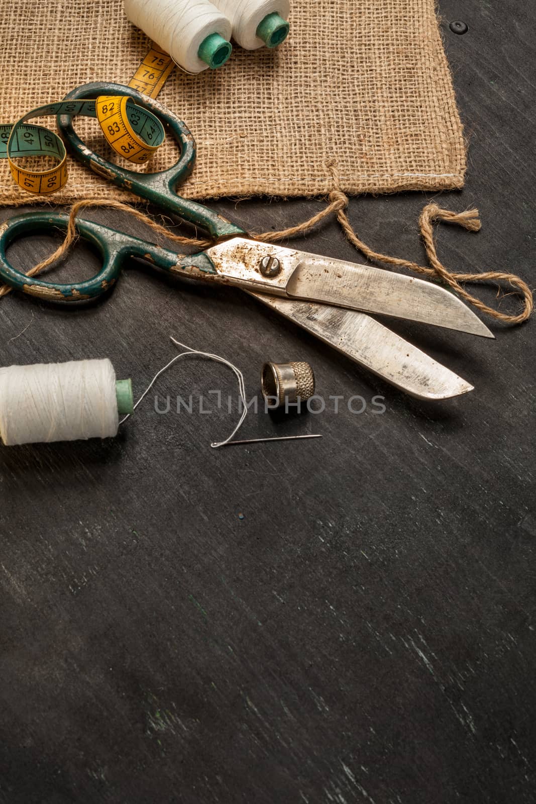 Retro sewing accessories on black wooden background by igor_stramyk