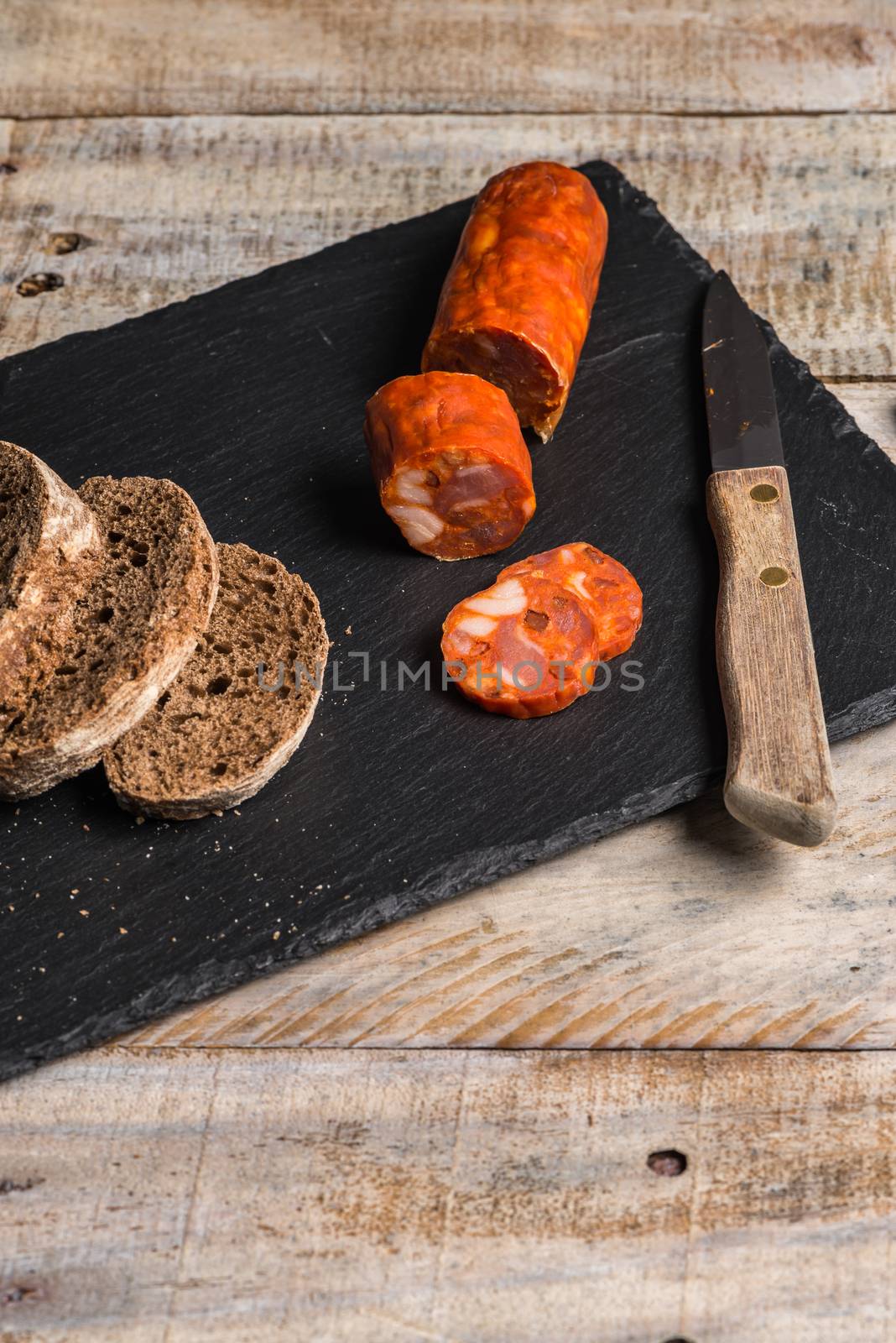 Malt loaf bread and chorizo slices on table.