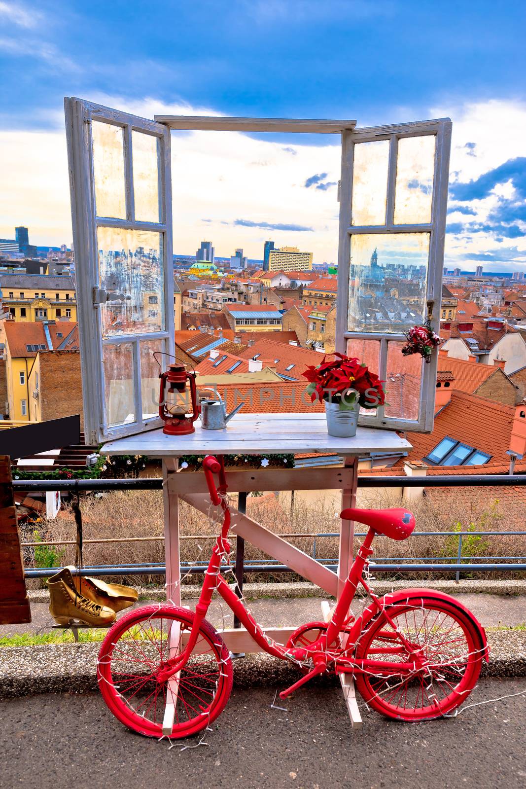 Idyllic Zagreb upper town Christmas market decorations, view through window on city rooftops and bicycle view, capital of Croatia