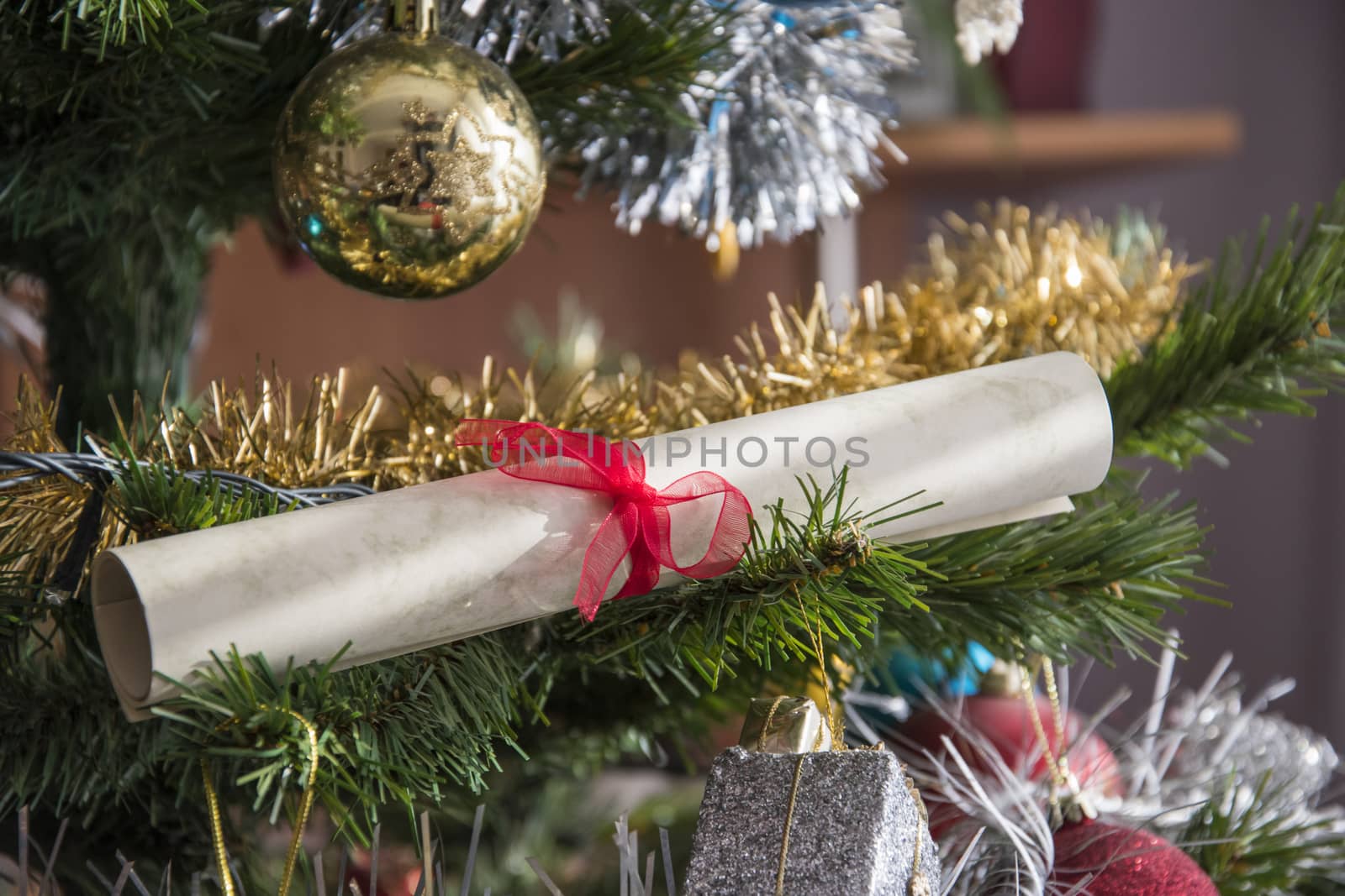 paper scroll, wishlist rolled up on christmas tree. Beautiful close up holiday photo.