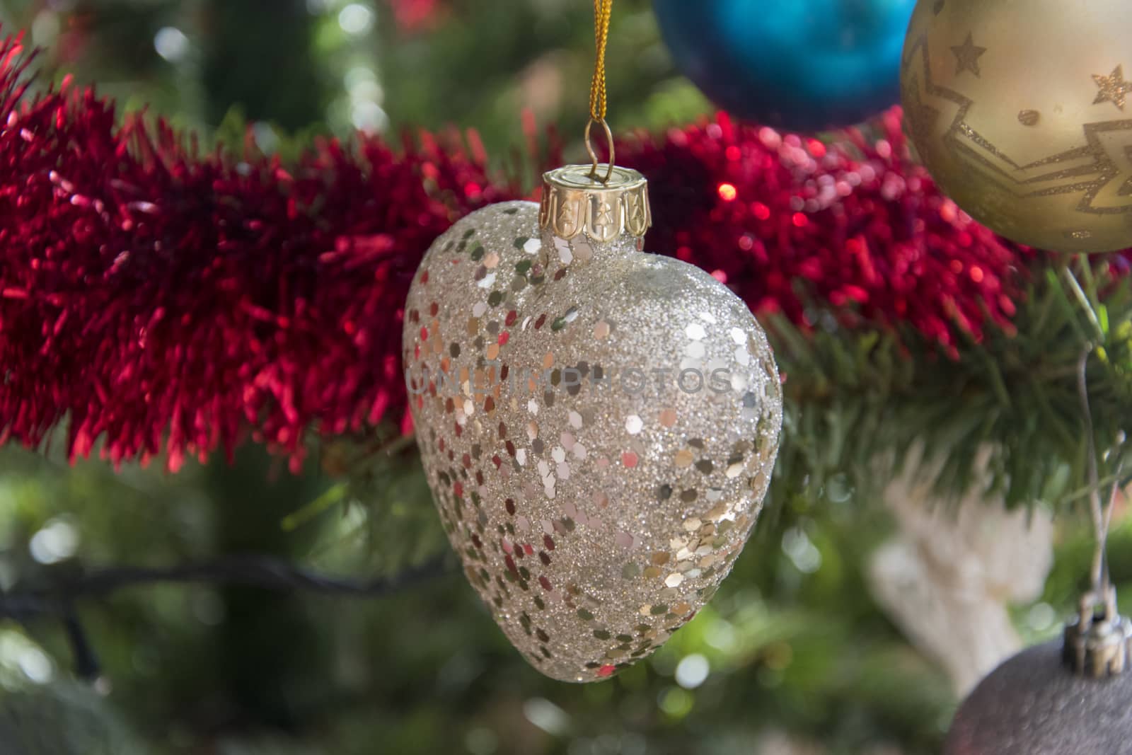 Heart ornament hanging on christmas tree. Beautiful close up holiday photo. 
