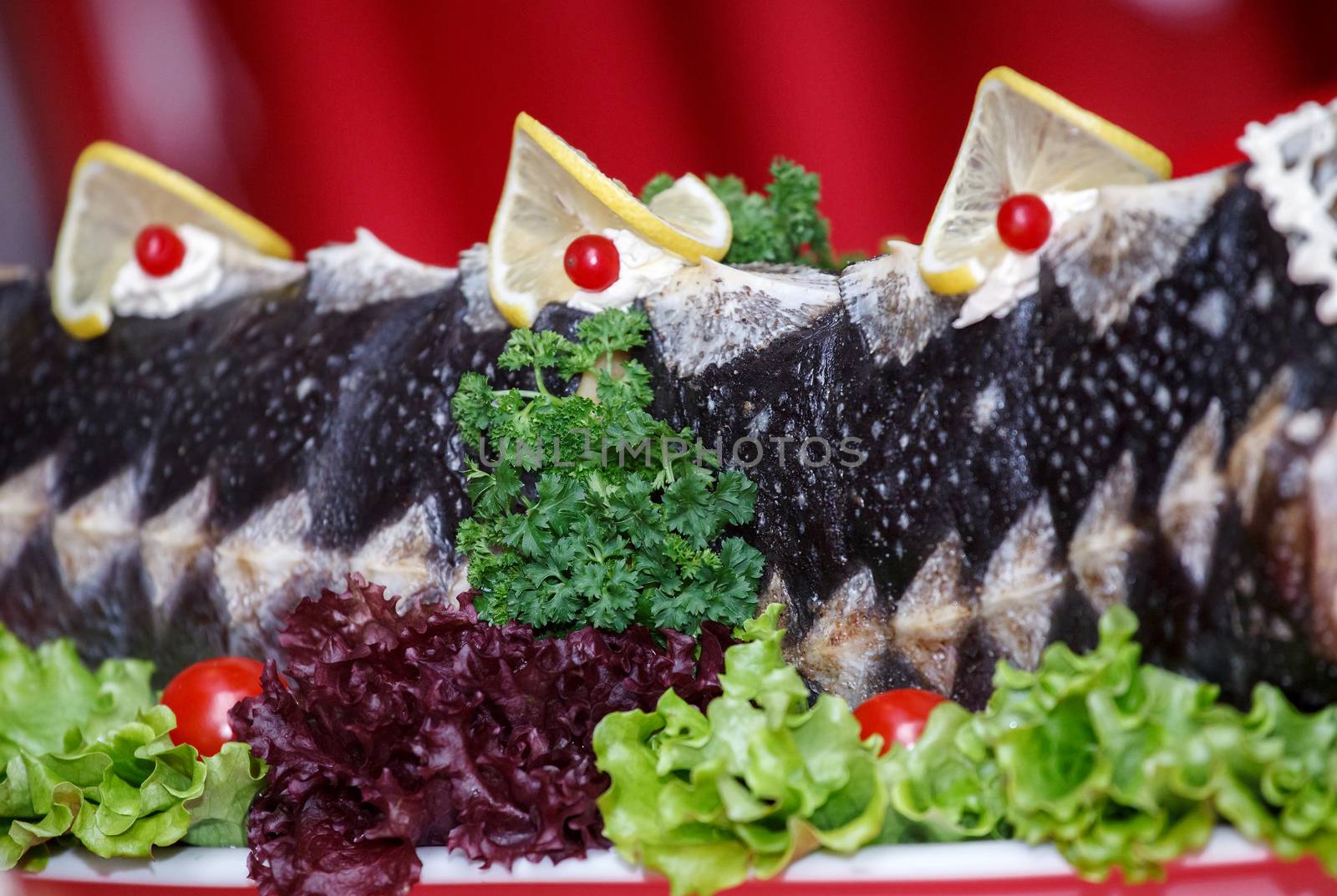 Fried sturgeon, decorated with lemons and greens