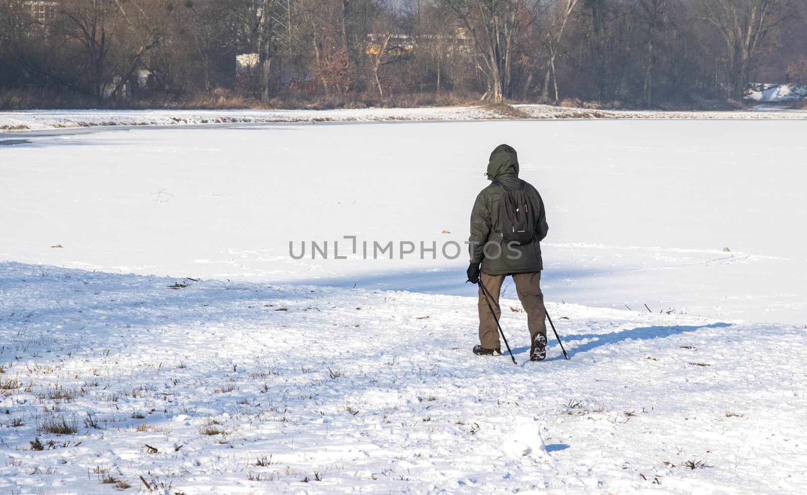 men with trekking poles on a lonely winter expedition photo