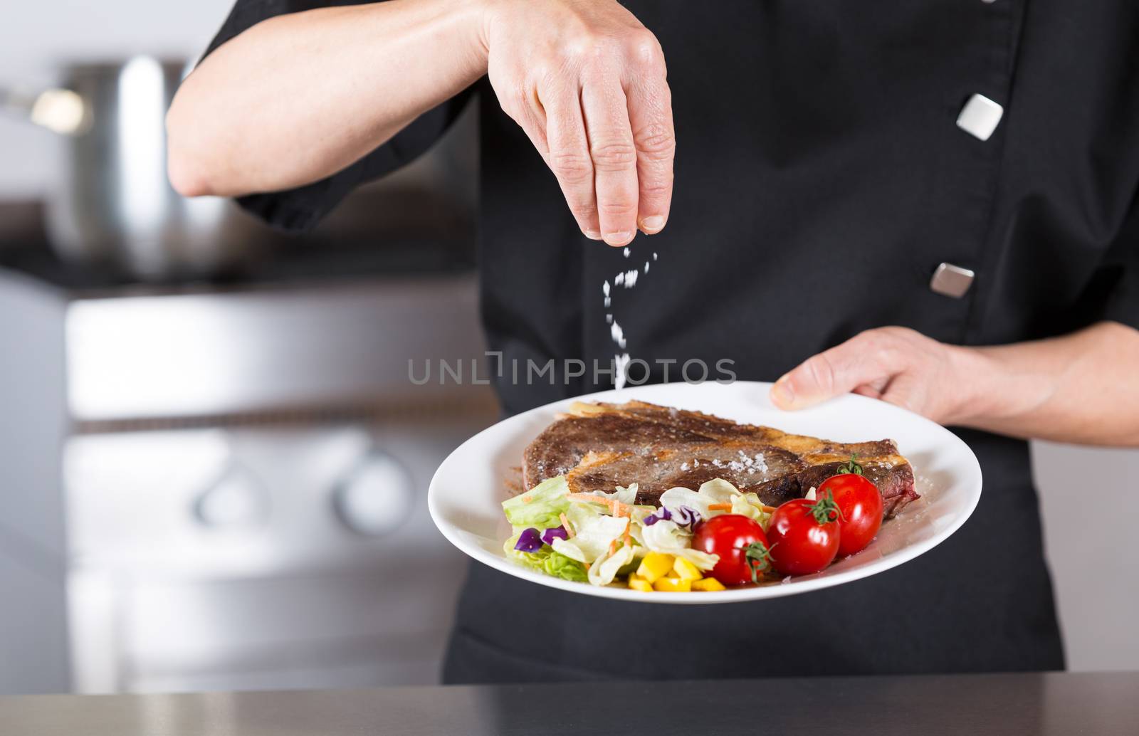 Chef finishing her plate and almost ready to serve at the table
