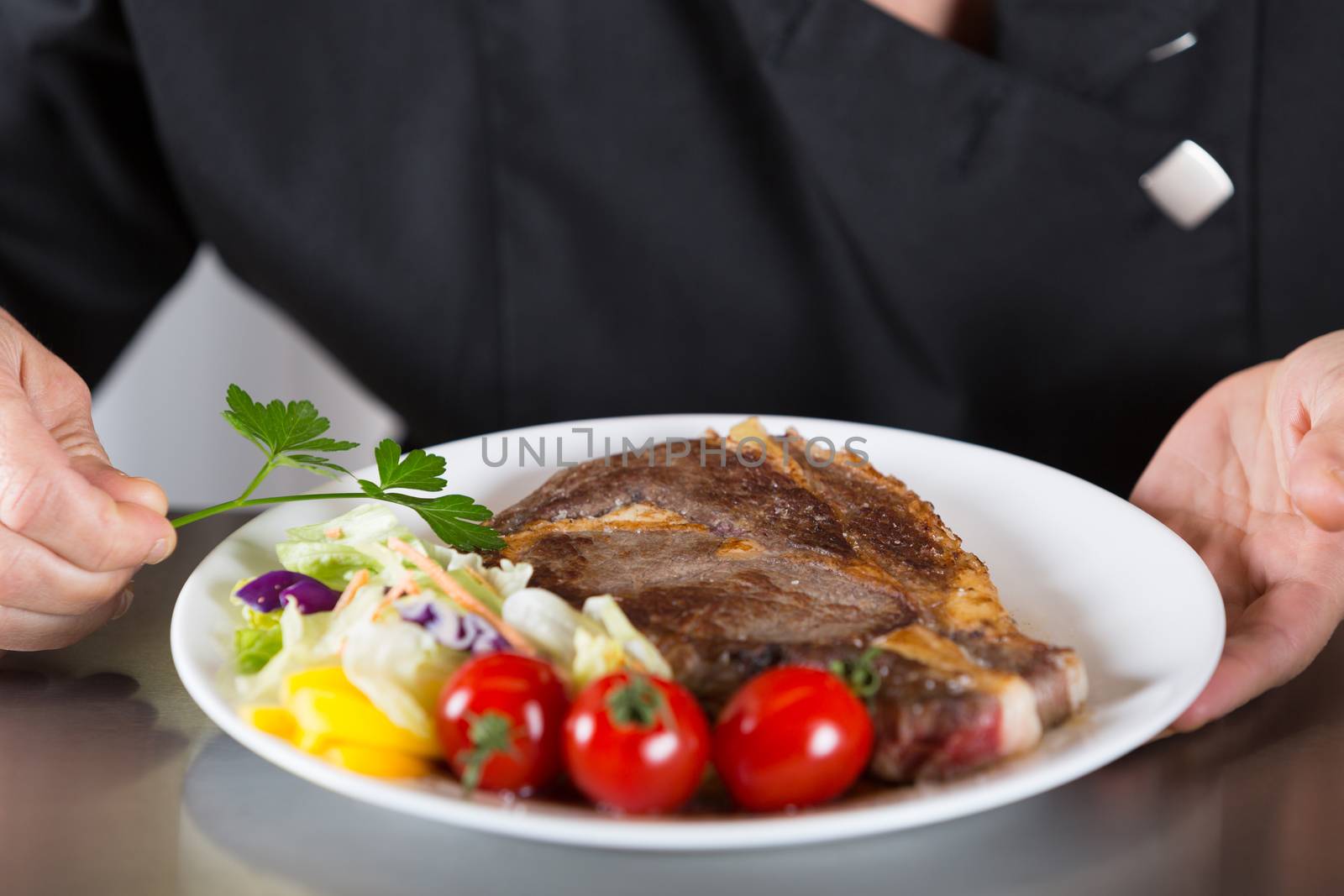 Chef finishing her plate and almost ready to serve at the table