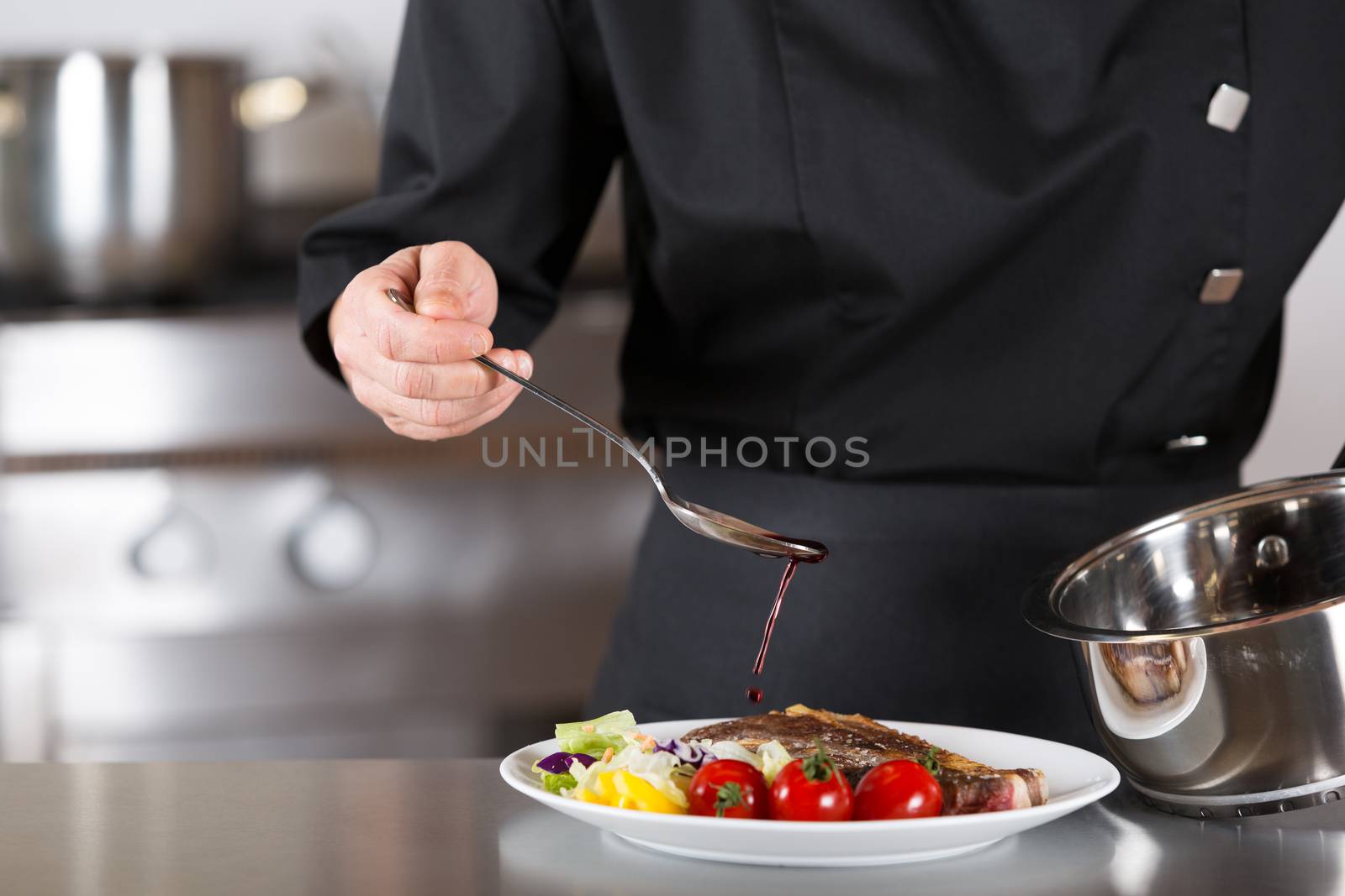 Chef finishing her plate and almost ready to serve at the table