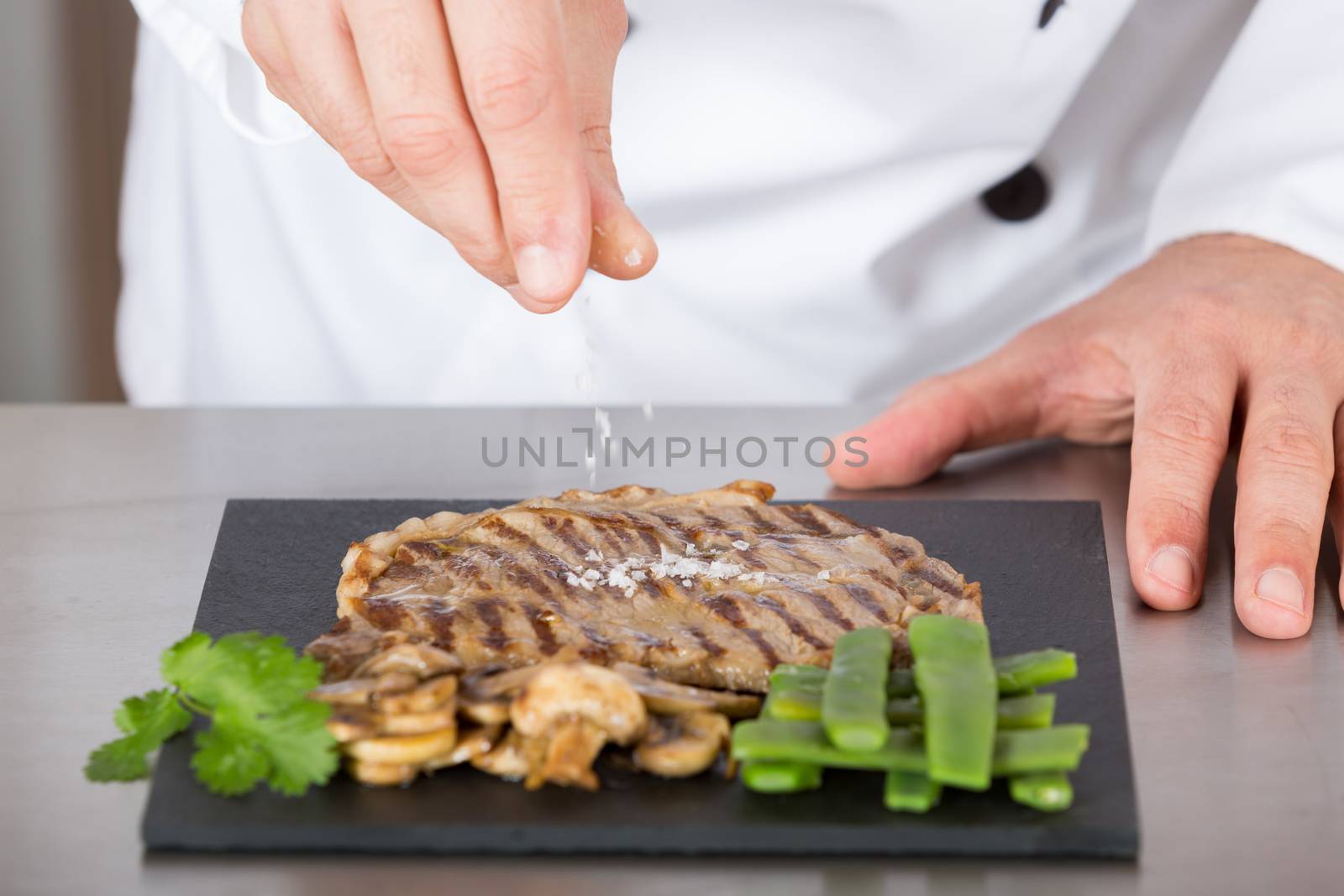 Chef finishing her plate and almost ready to serve at the table