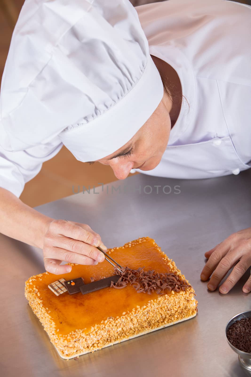 Pastry chef decorating cake yolk and cream