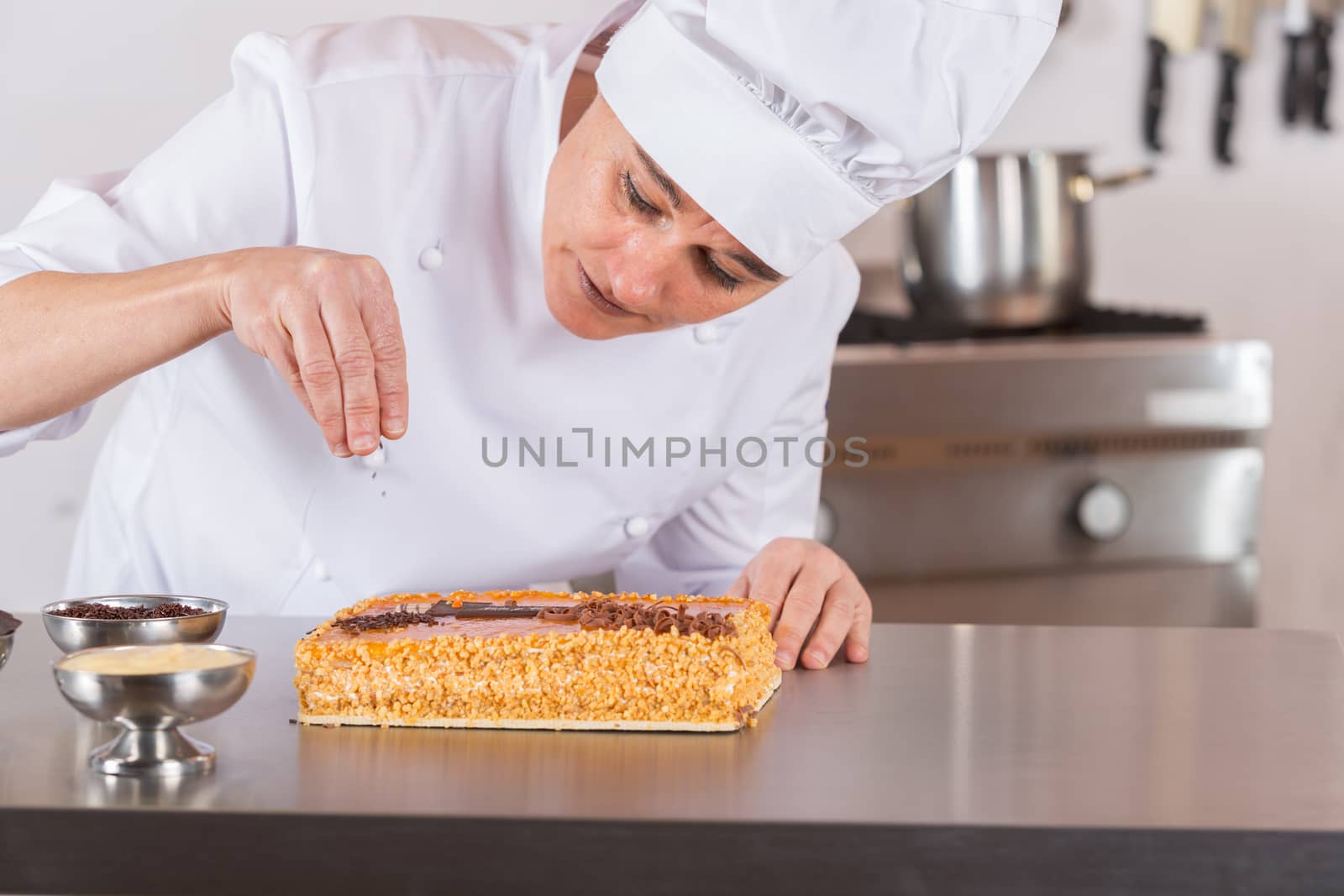 Pastry chef decorating cake yolk and cream