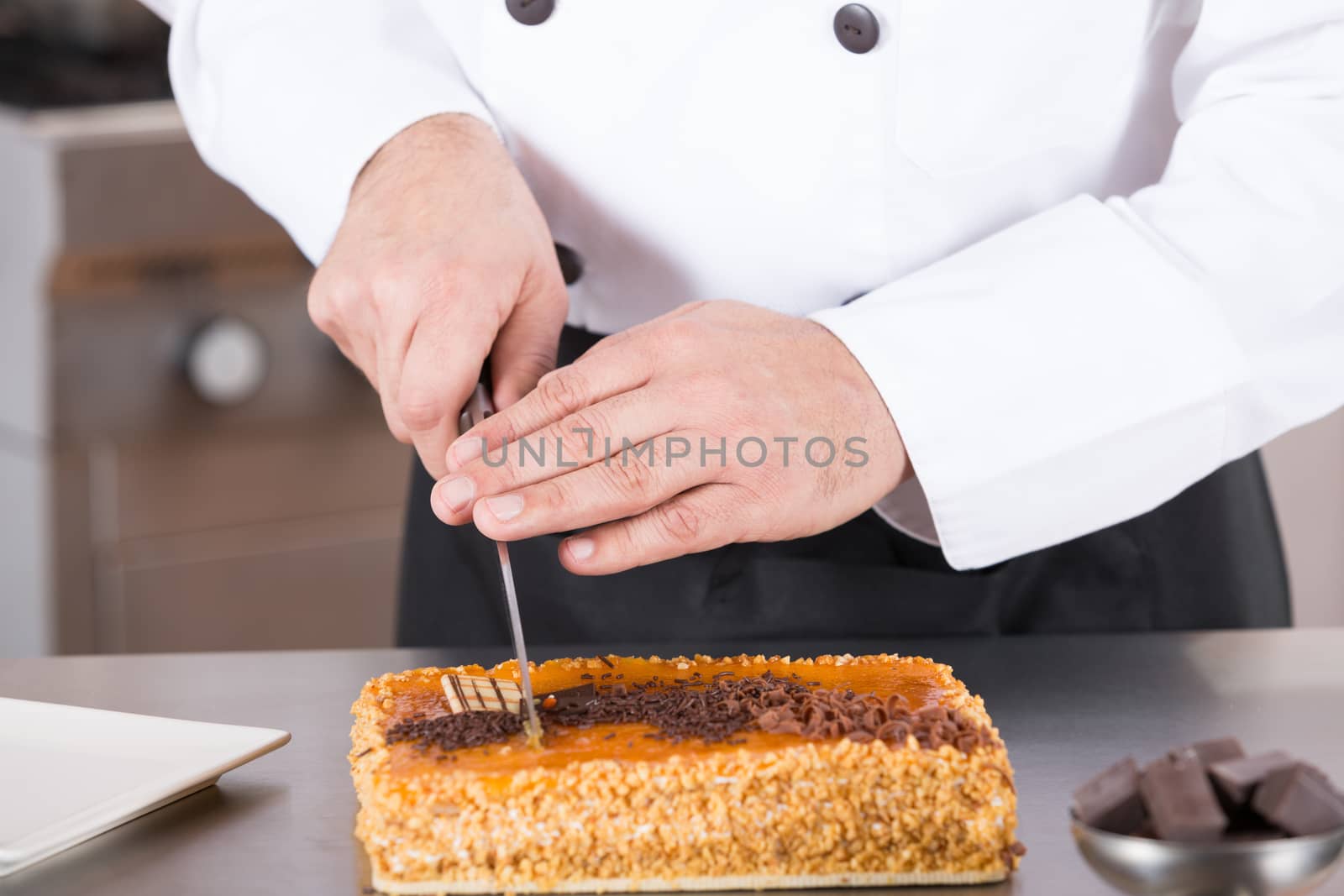 Pastry chef cutting a cake yolk and cream