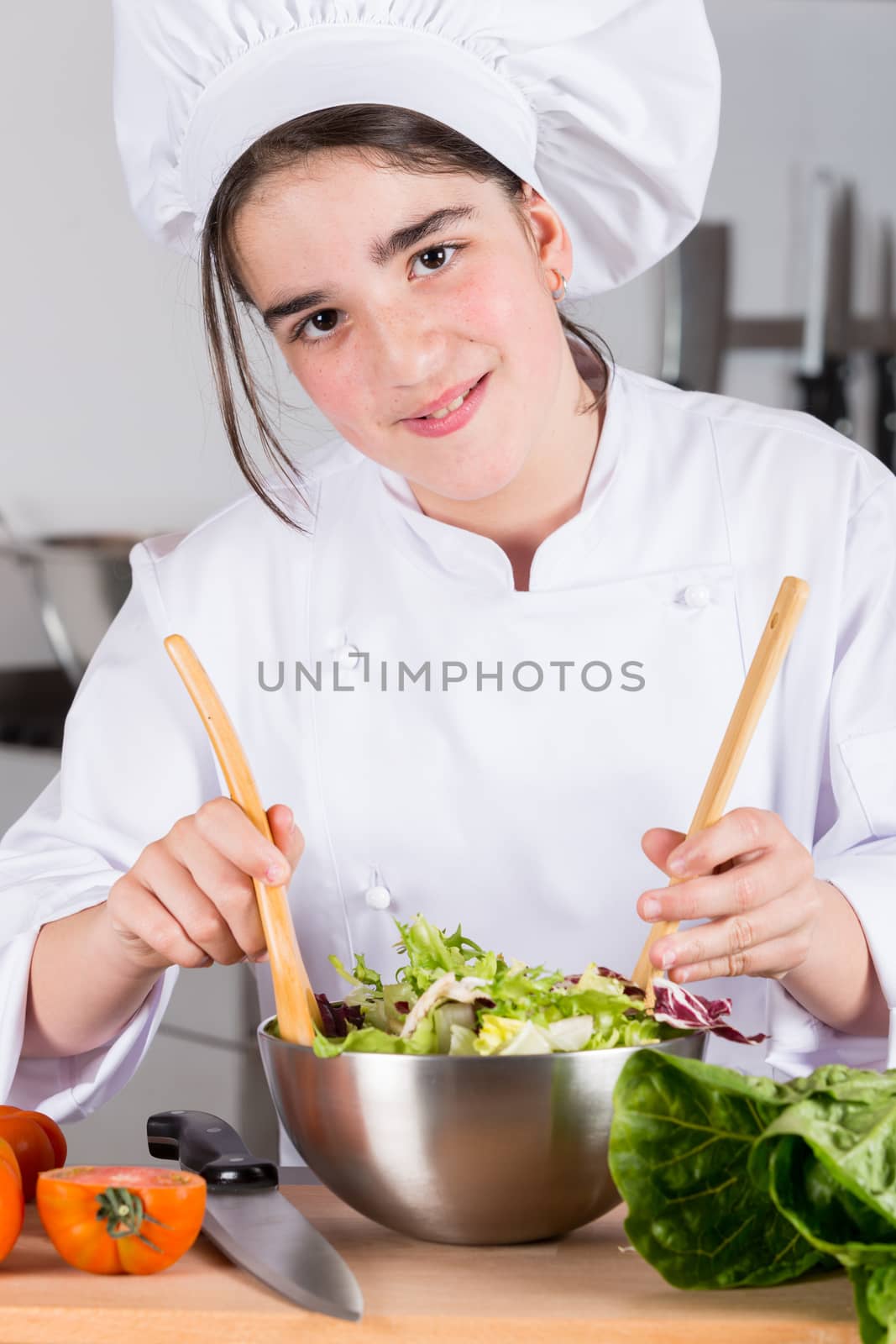 Teen girl in the kitchen preparing a salad