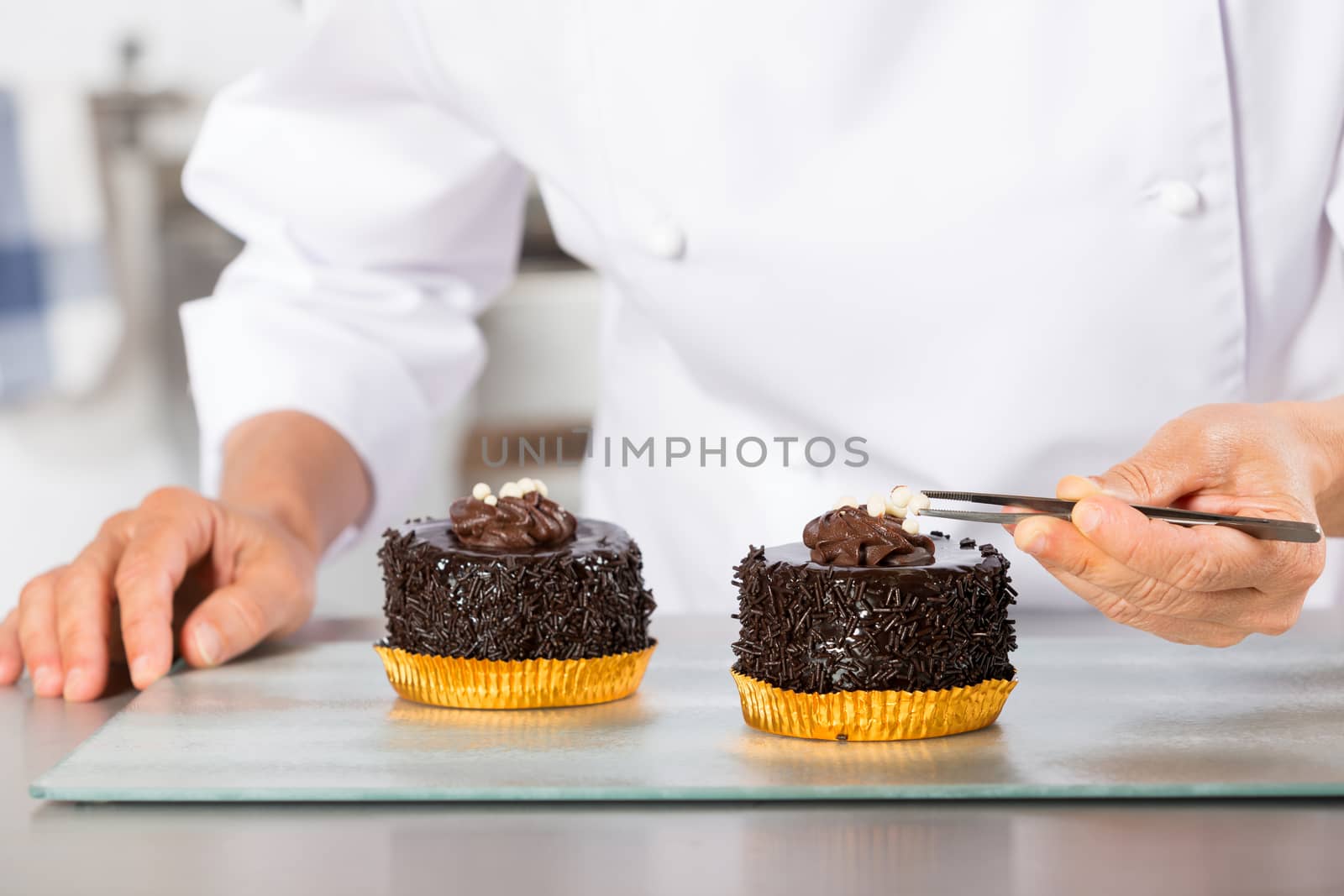 Chef decorating finishing two cakes of chocolate and cream