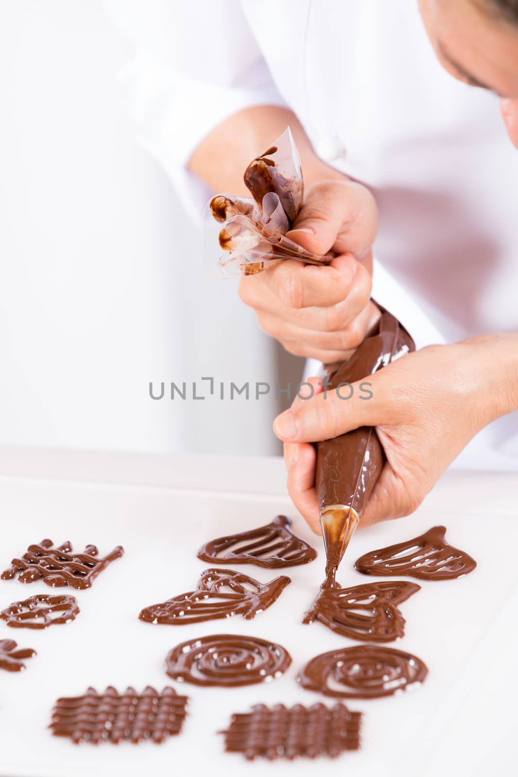 Chef making figures with chocolate to decorate a cake