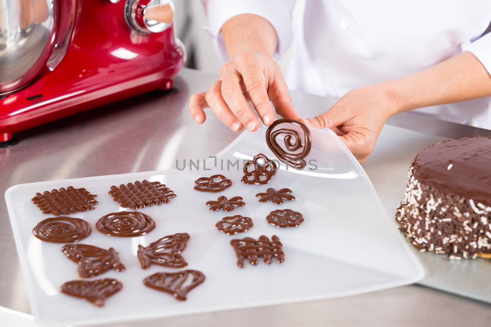 Chef making figures with chocolate to decorate a cake