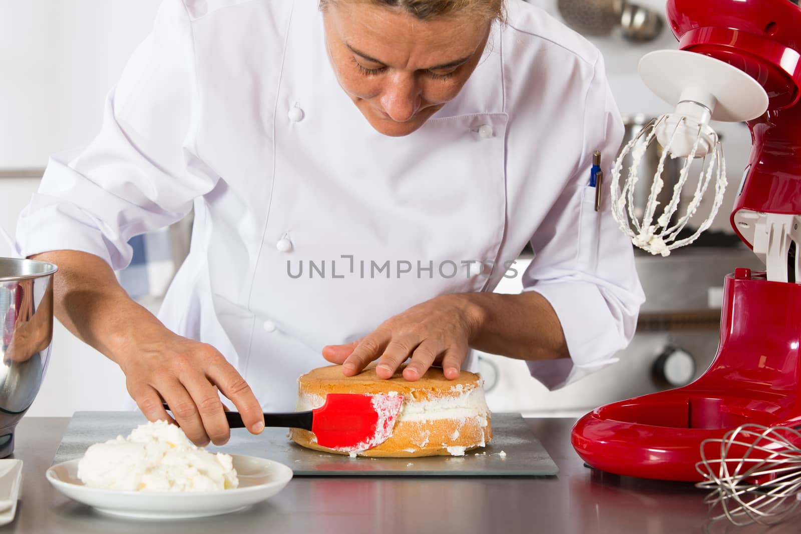 Chef decorating a delicious cake with cream