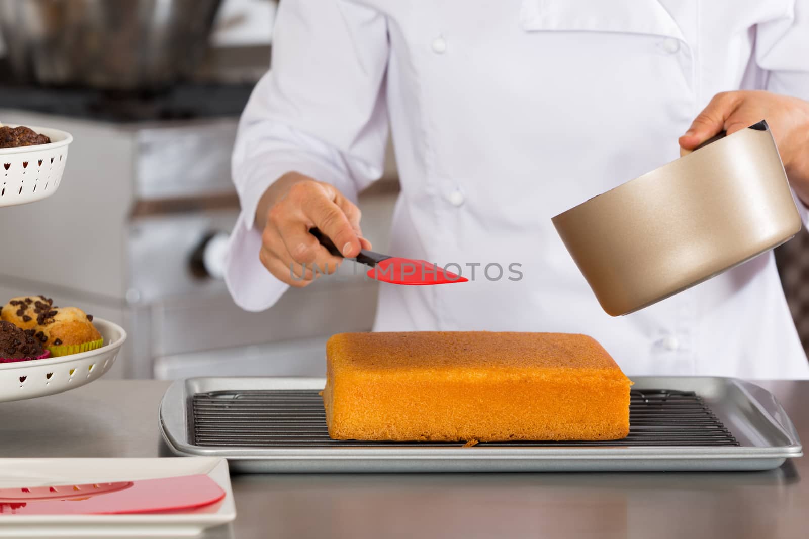 Pastry chef in the kitchen decorating a cake of chocolate