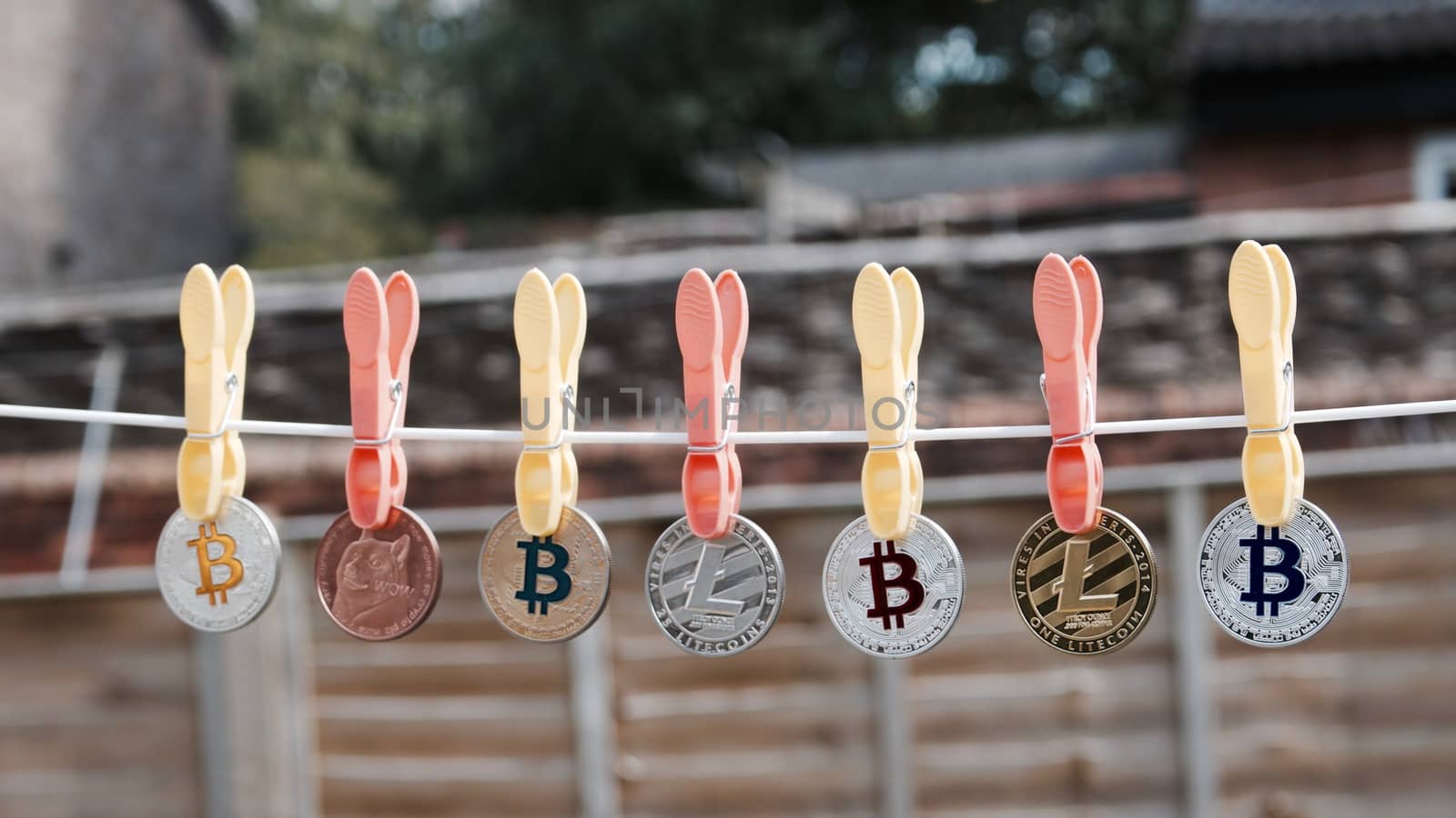 Digital currency physical coins on the line with laundry clips.
