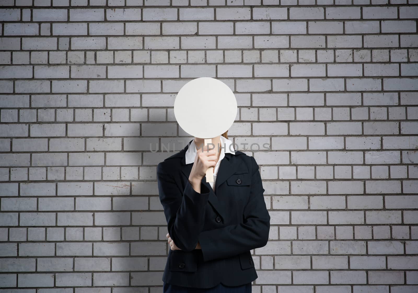 Businesswoman hiding her face behind round banner with smiley