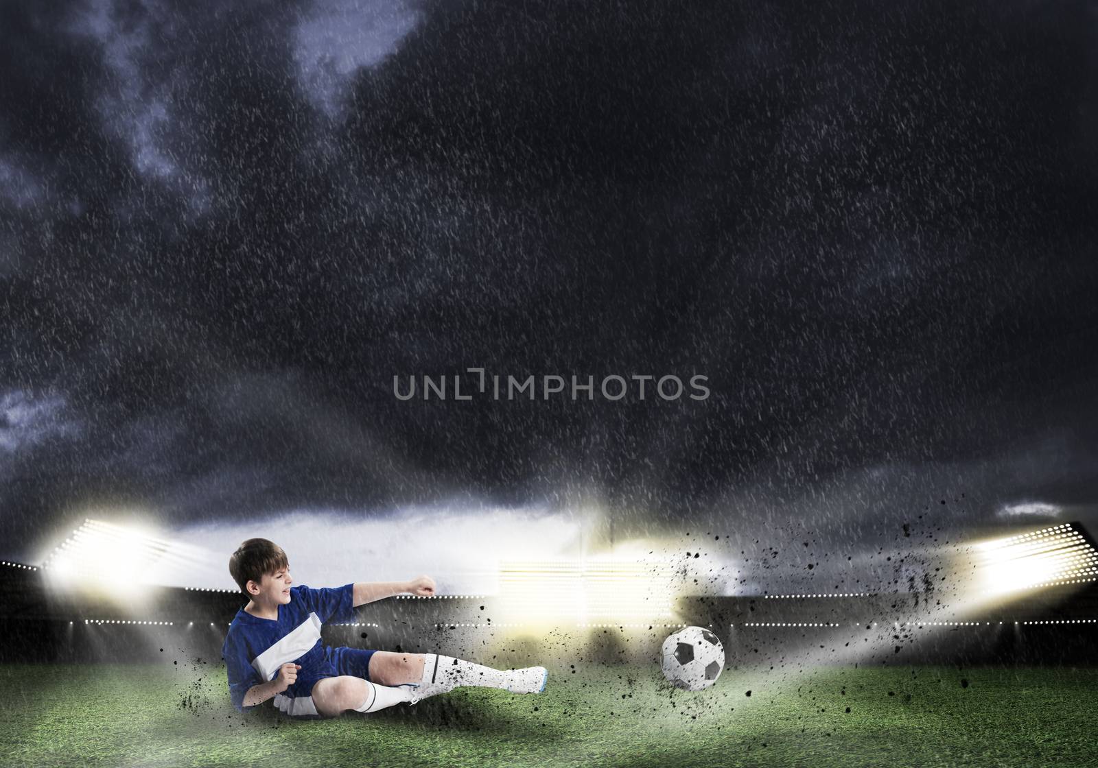 Excited boy football player at stadium kicking ball