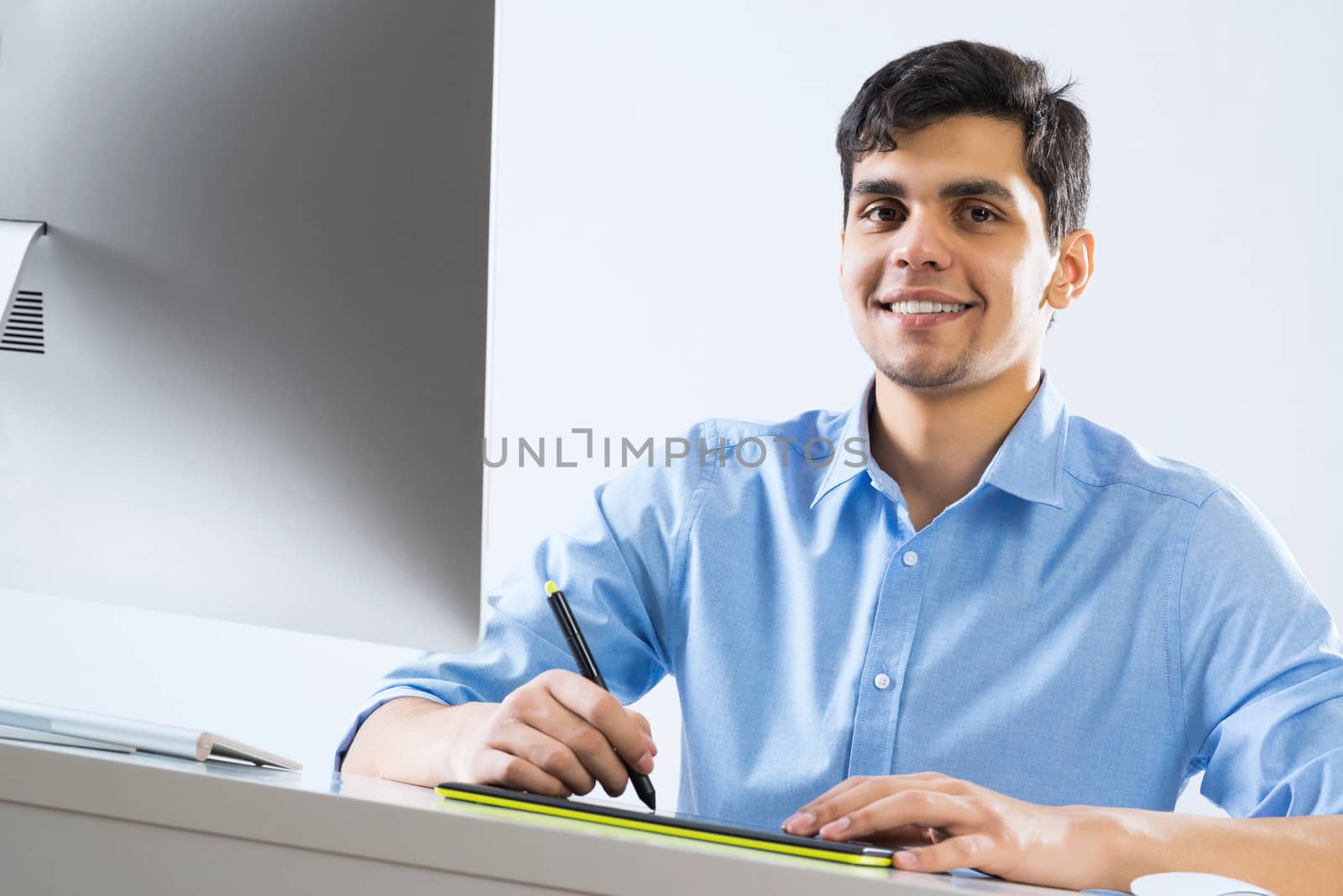 Young graphic designer sitting at desk and working