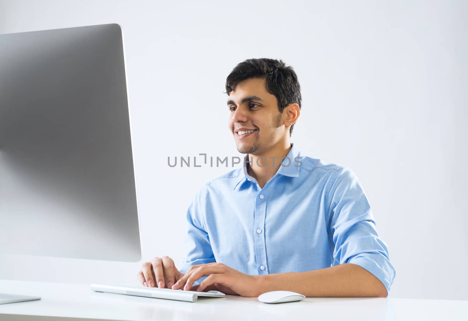 Young man sitting at desk and working on computer