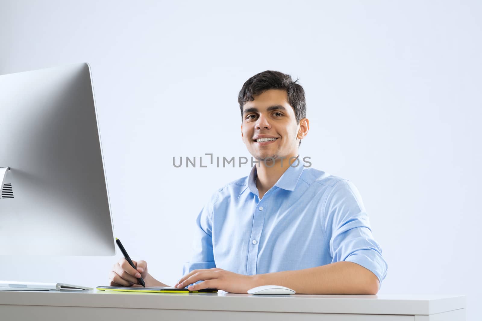 Young graphic designer sitting at desk and working