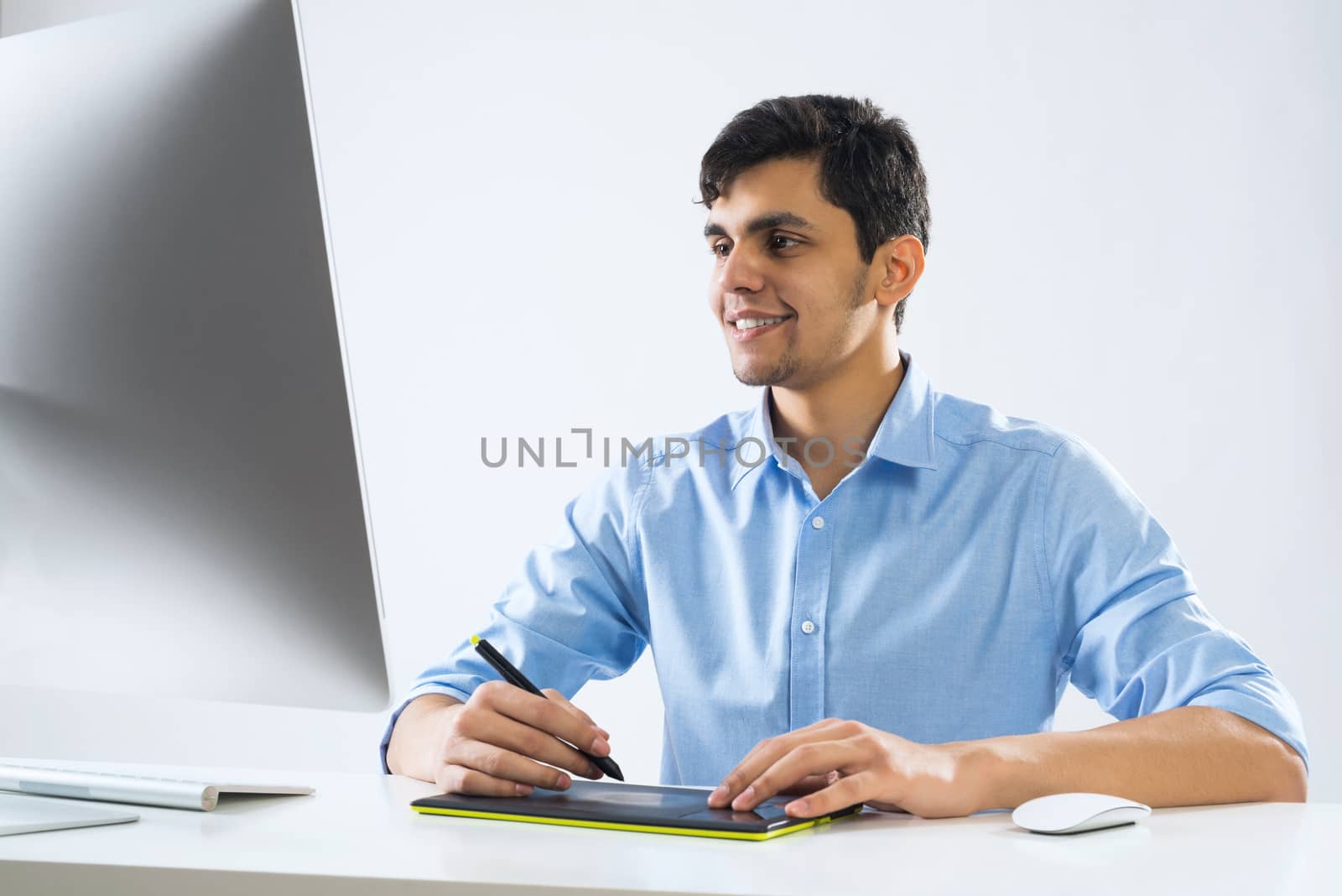 Young graphic designer sitting at desk and working