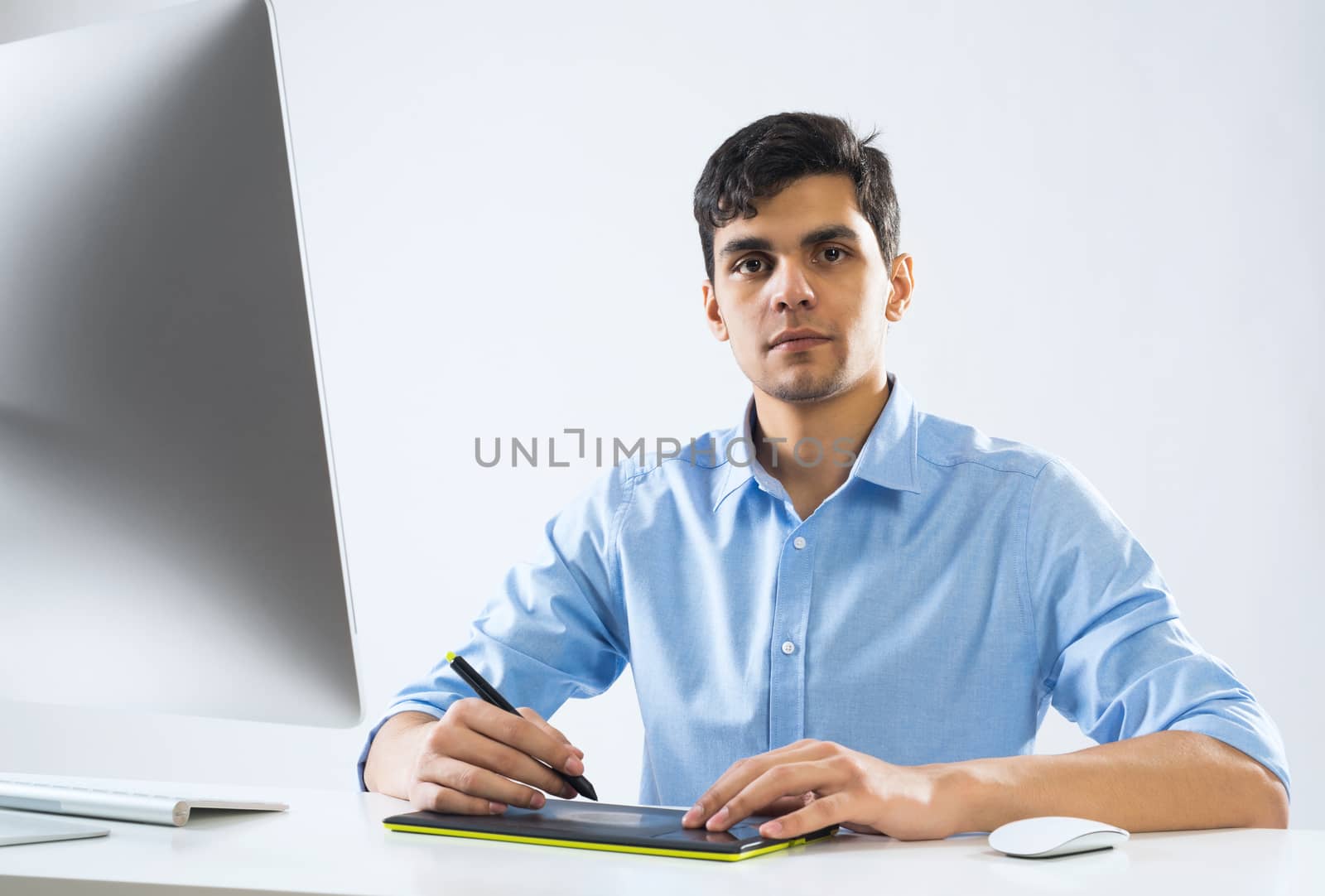 Young graphic designer sitting at desk and working