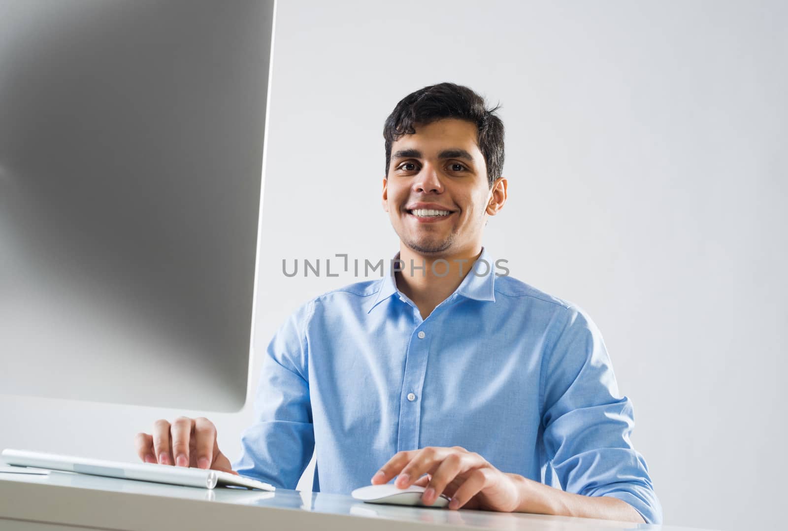 Young man sitting at desk and working on computer