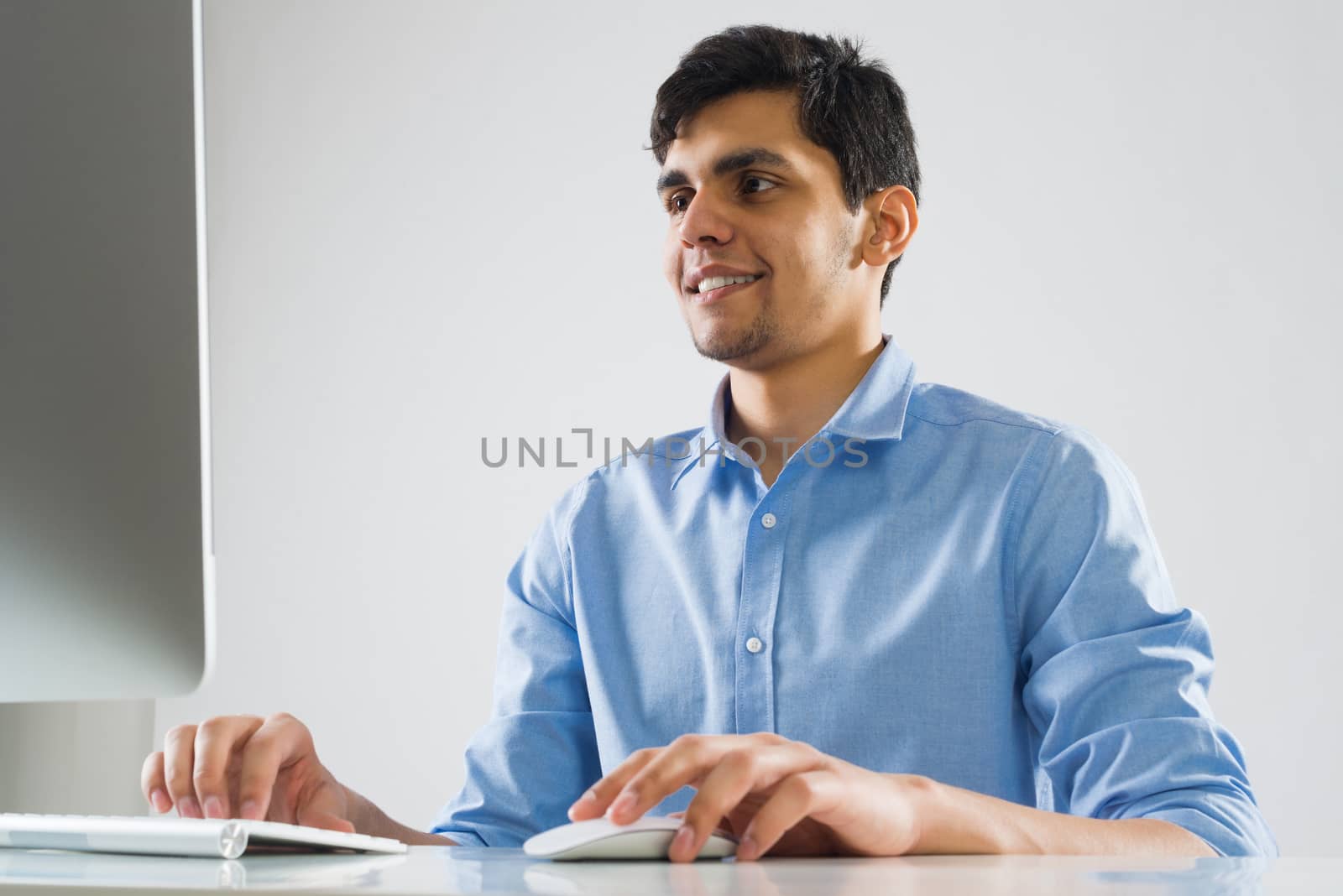 Young man sitting at desk and working on computer