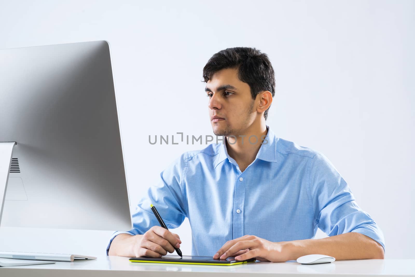 Young graphic designer sitting at desk and working