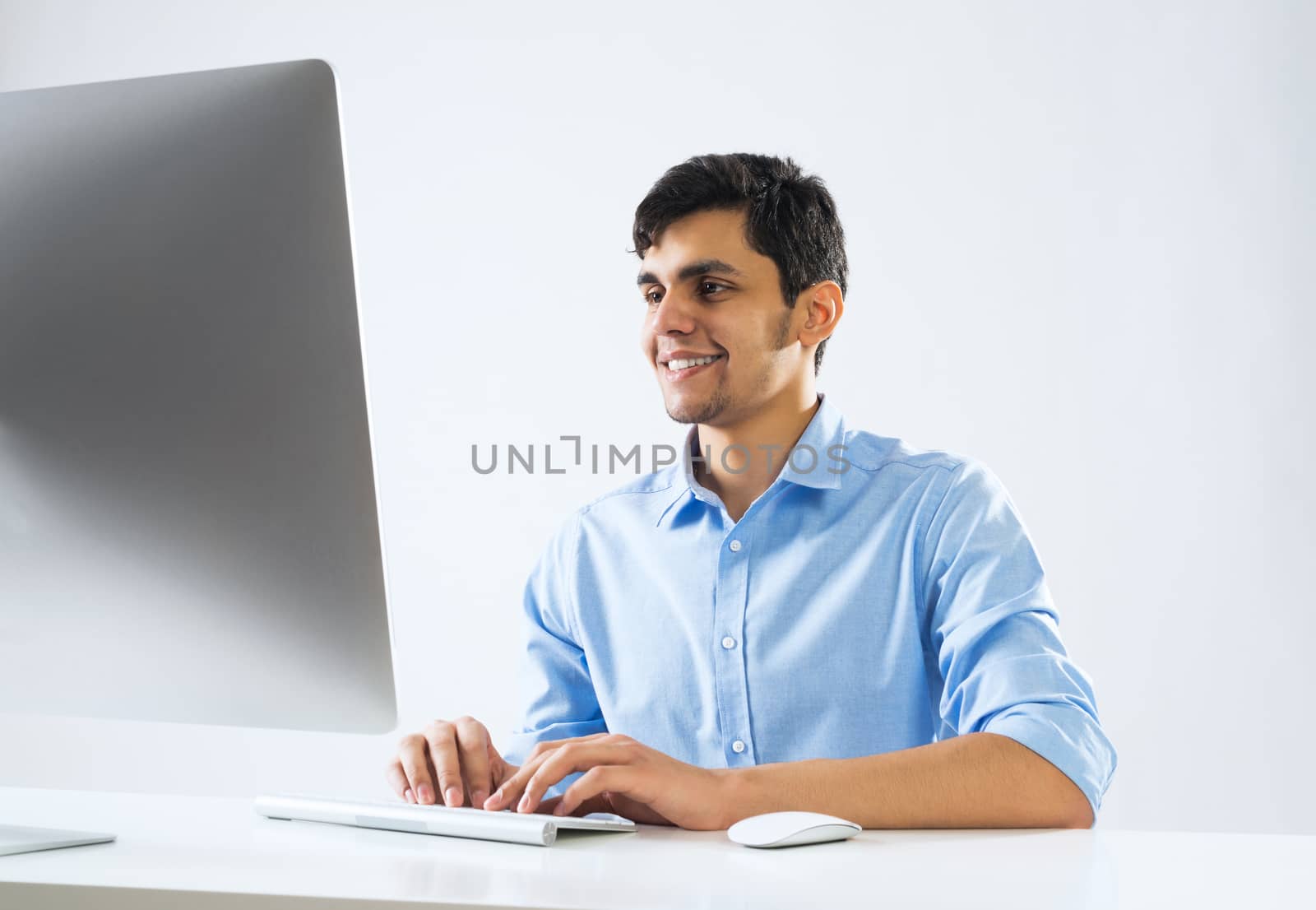 Young man sitting at desk and working on computer