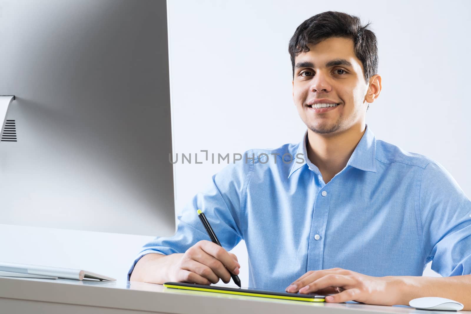 Young graphic designer sitting at desk and working