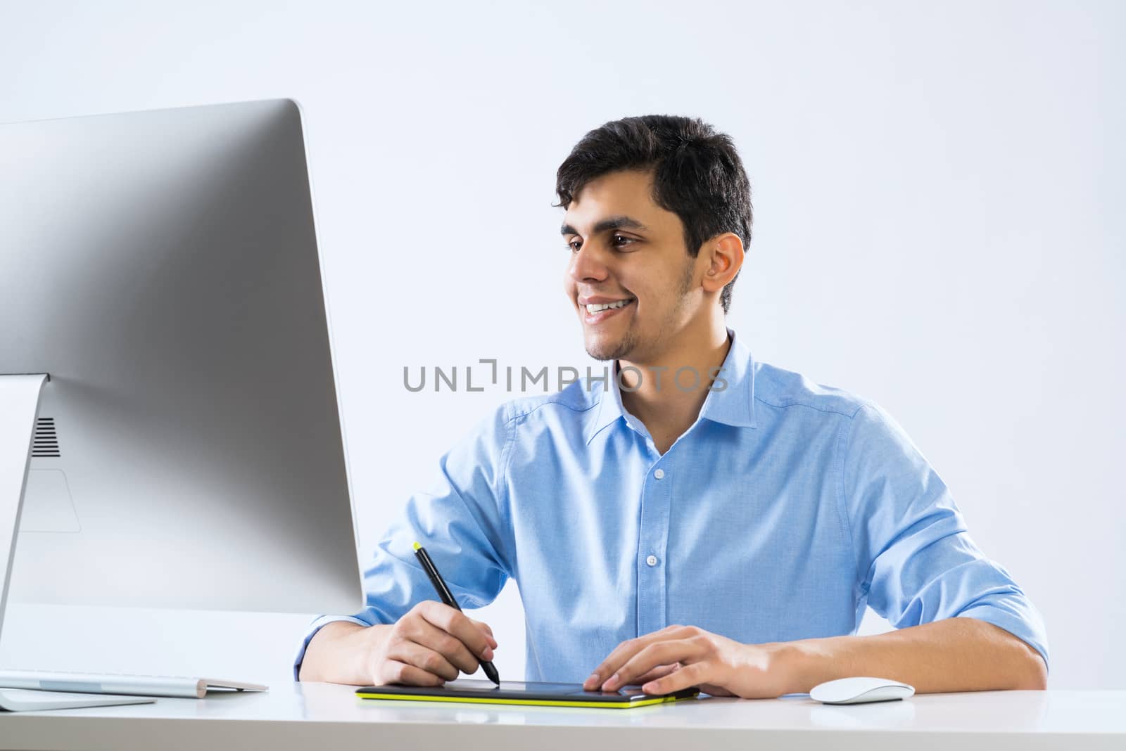 Young graphic designer sitting at desk and working