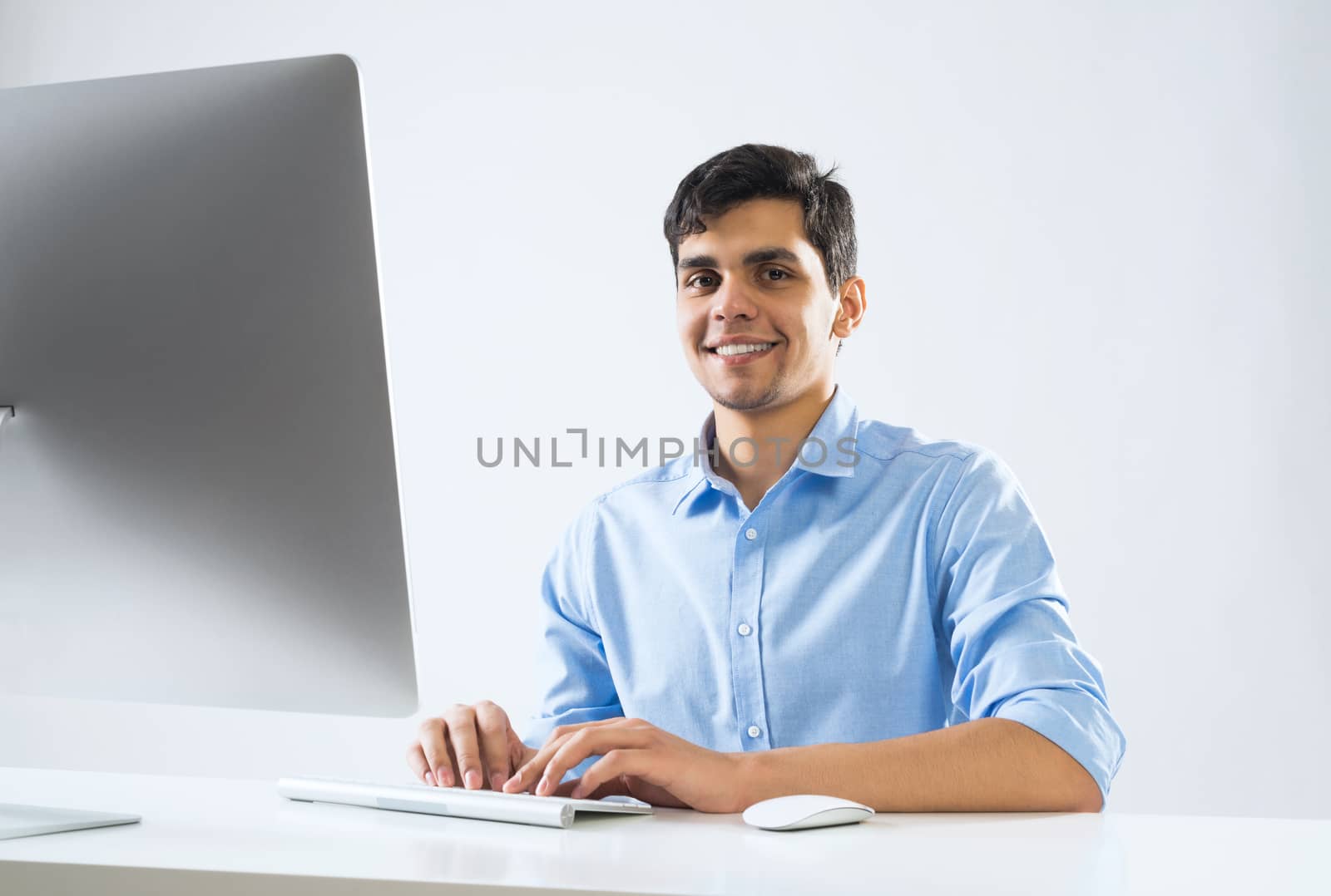 Young man sitting at desk and working on computer