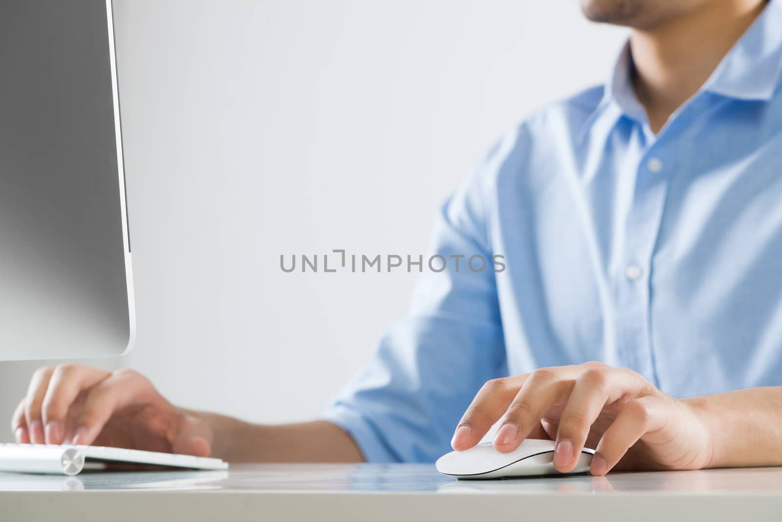 Young man sitting at desk and typing on keyboard