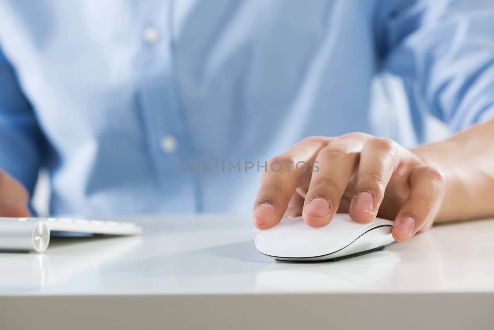 Young man sitting at desk and typing on keyboard