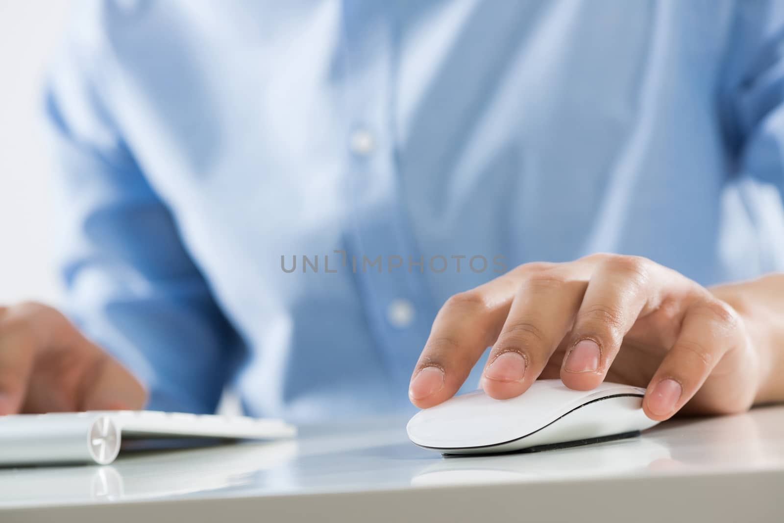 Young man sitting at desk and typing on keyboard