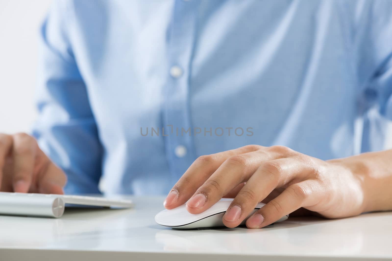 Young man sitting at desk and typing on keyboard